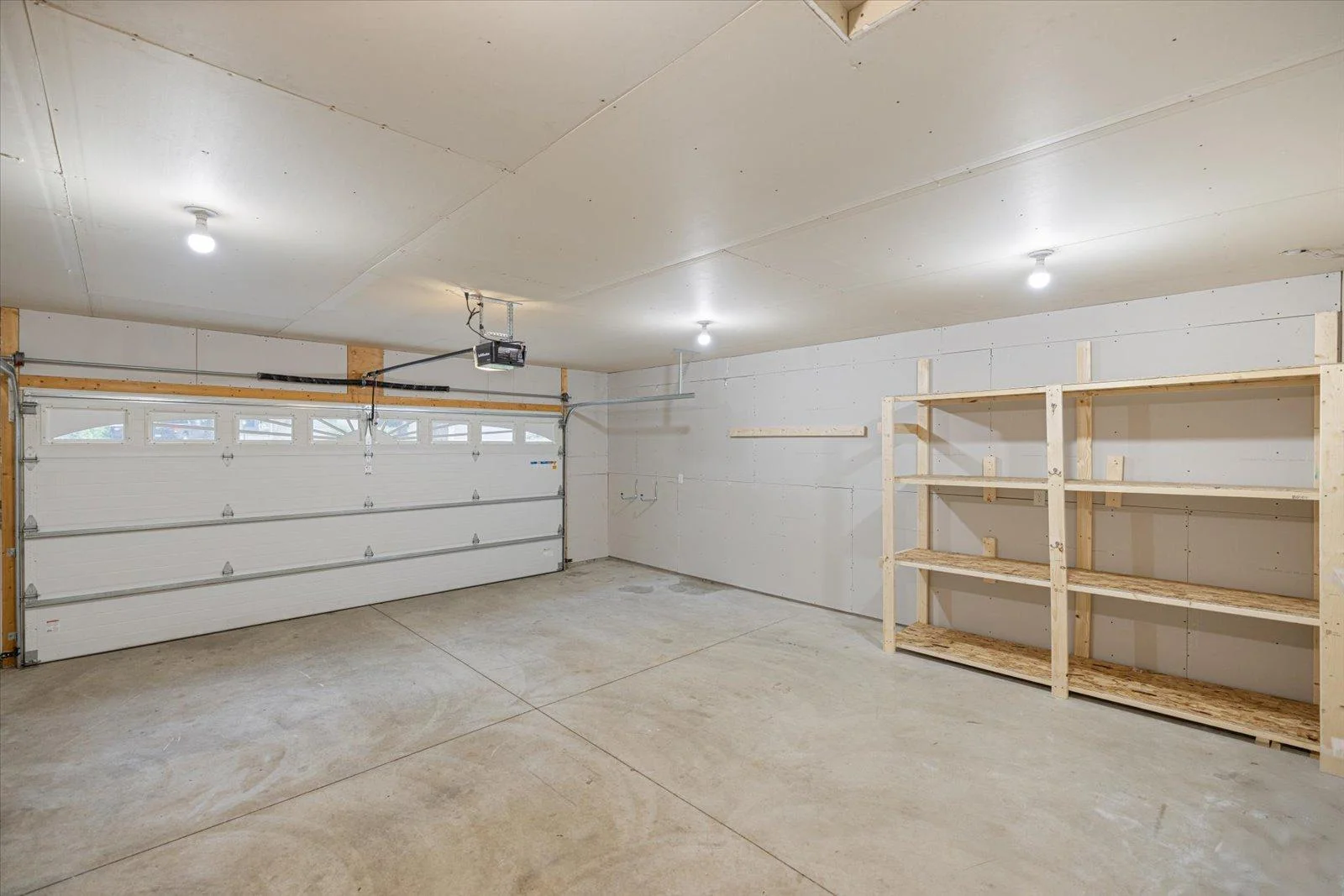 View of the large, insulated garage, with shelving for storage.