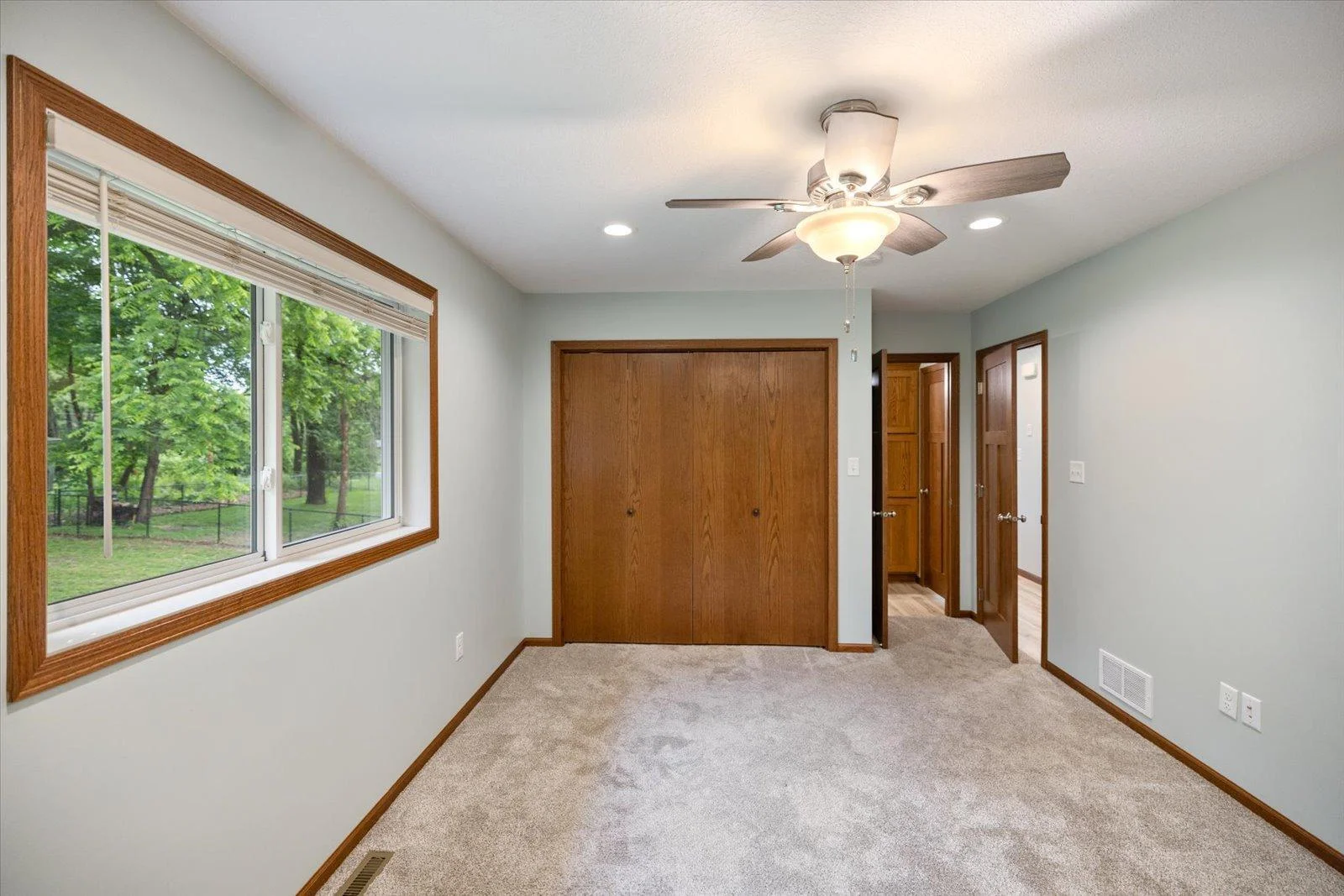 Primary Bedroom in the main level with ceiling light/fan and a walkthrough to the bathroom. The large closet has a light.