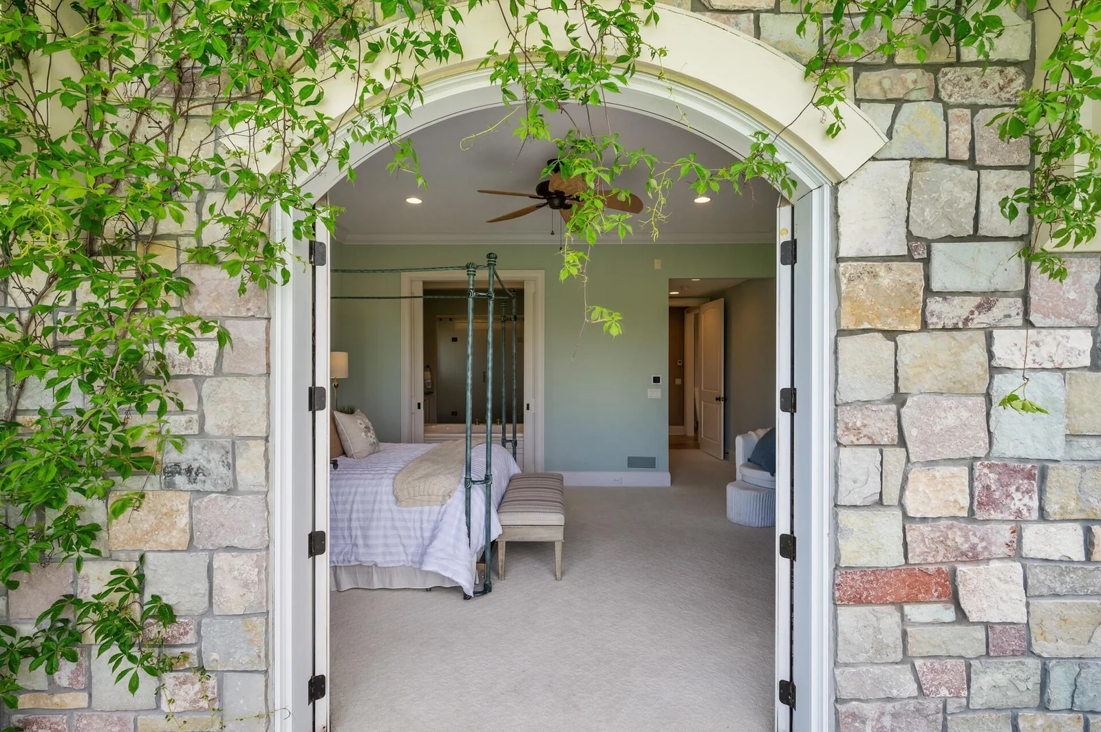 A unique stone archway welcomes you into the luxurious primary suite from the private balcony.