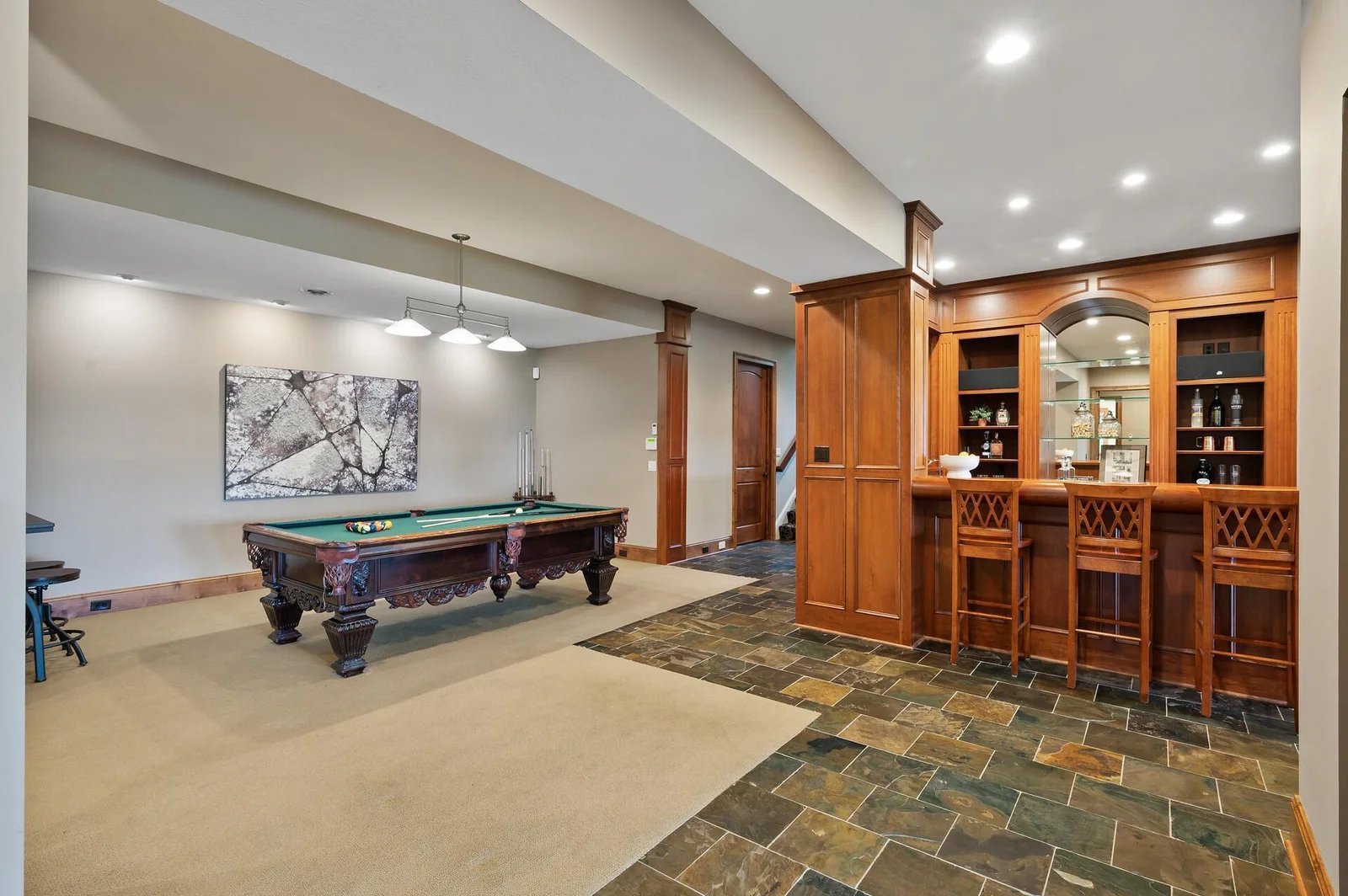 The impressive custom bar is ready for your next gathering, conveniently located near the pool table in the lower level.