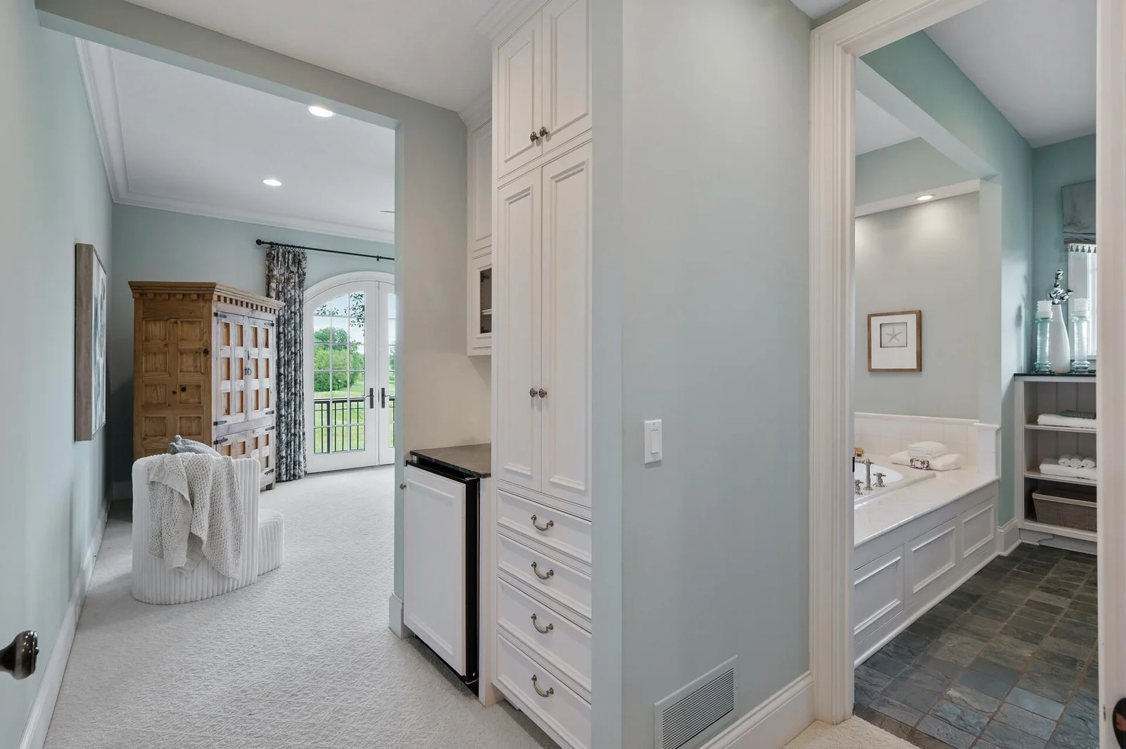 Well-appointed transition area connecting the spacious primary suite and the luxurious ensuite bathroom.