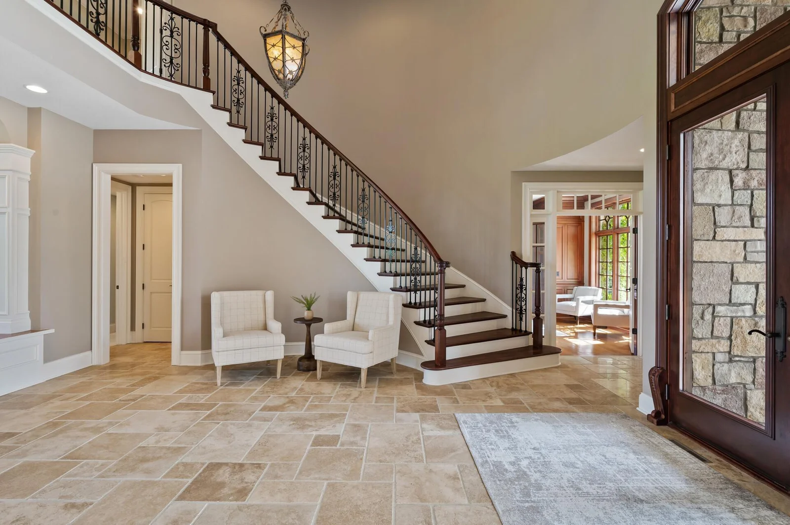 The elegant curved staircase with its ornate iron balusters is a stunning focal point of the grand foyer.