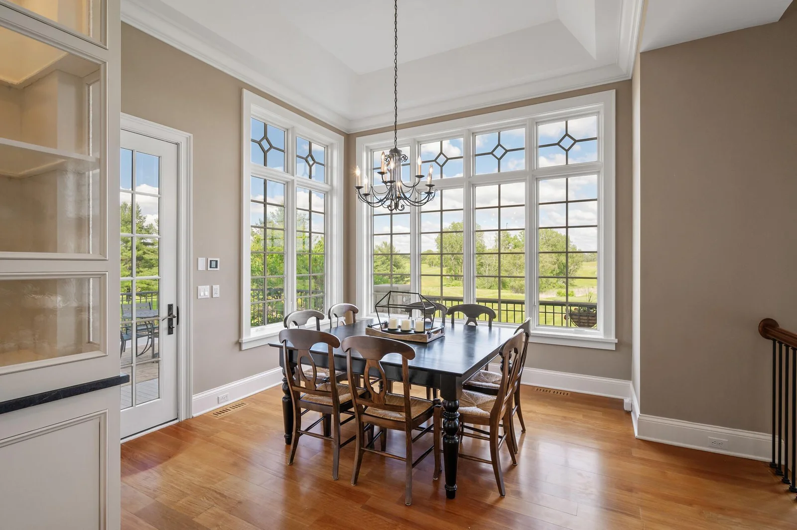 Sunlight streams into the charming informal dining area off the kitchen through its large, picturesque windows.