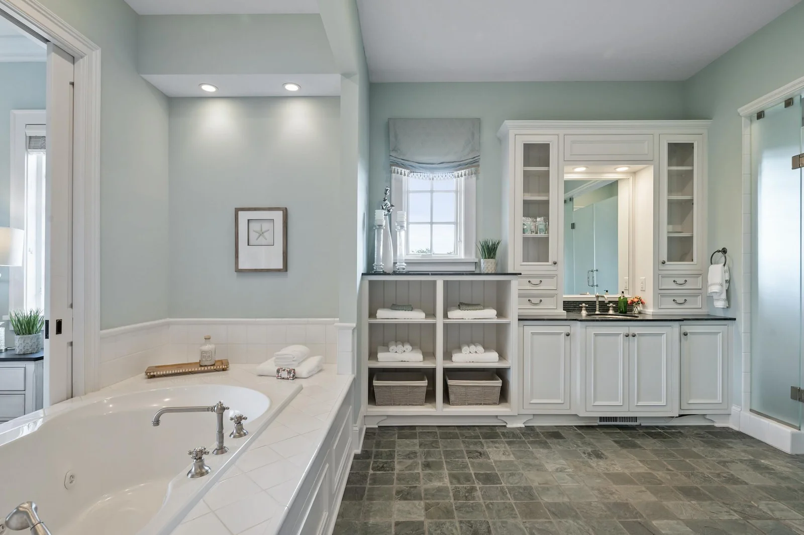 Ample storage and thoughtful design define this primary ensuite. Enjoy organized luxury with built-in shelving and elegant cabinetry.