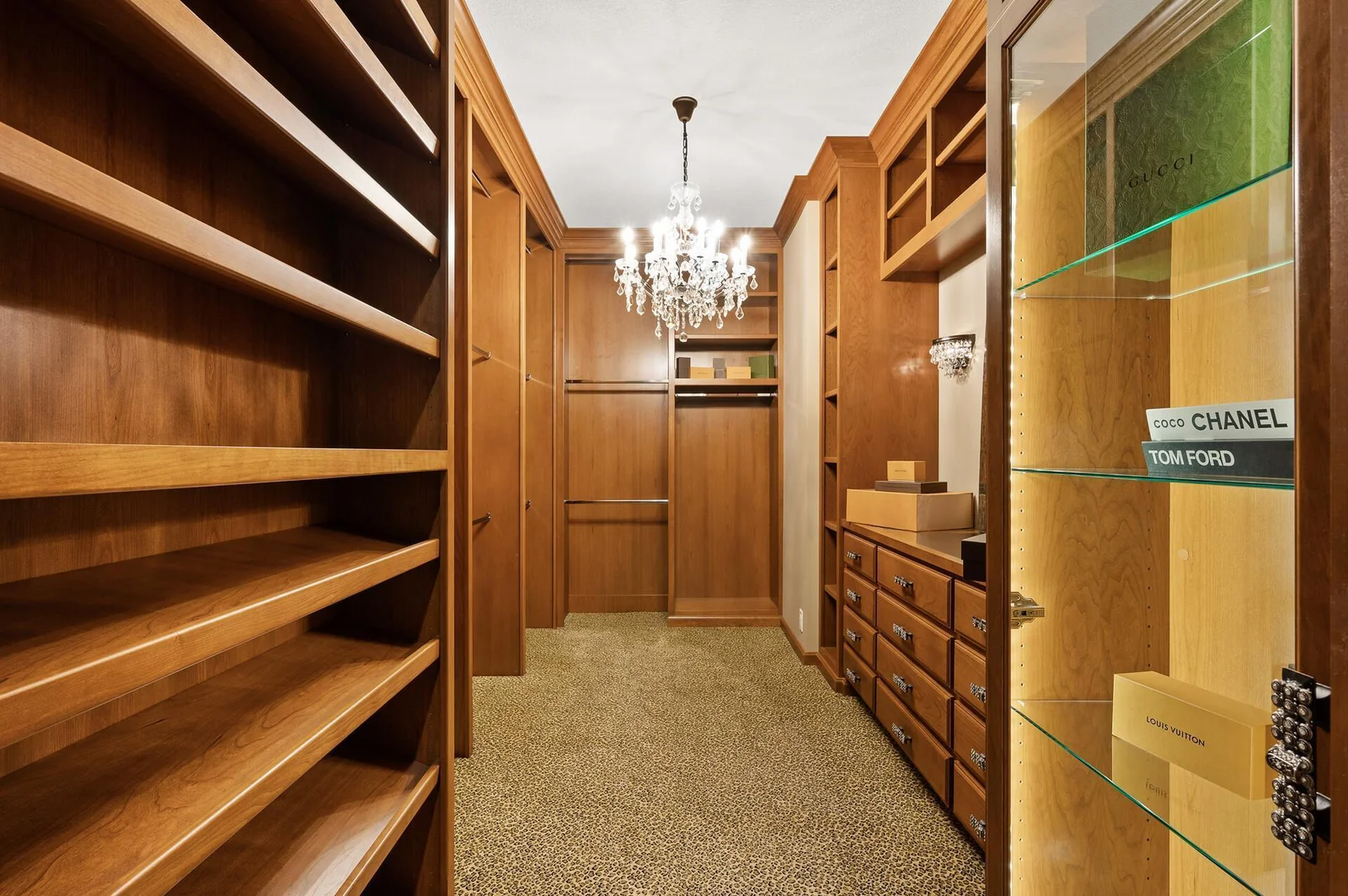 Elegant wood finishes and thoughtful lighting enhance this custom closet on the lower level, perfect for showcasing and storing your prized possessions.