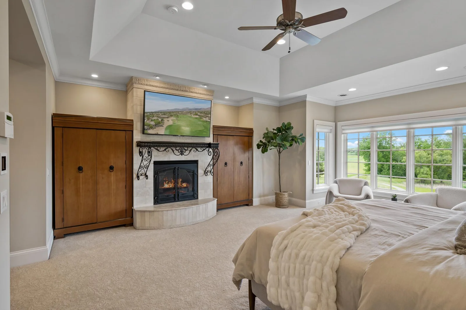 Thoughtfully designed, the second primary suite features a cozy fireplace, practical built-in storage, and a bright sitting area with scenic views.
