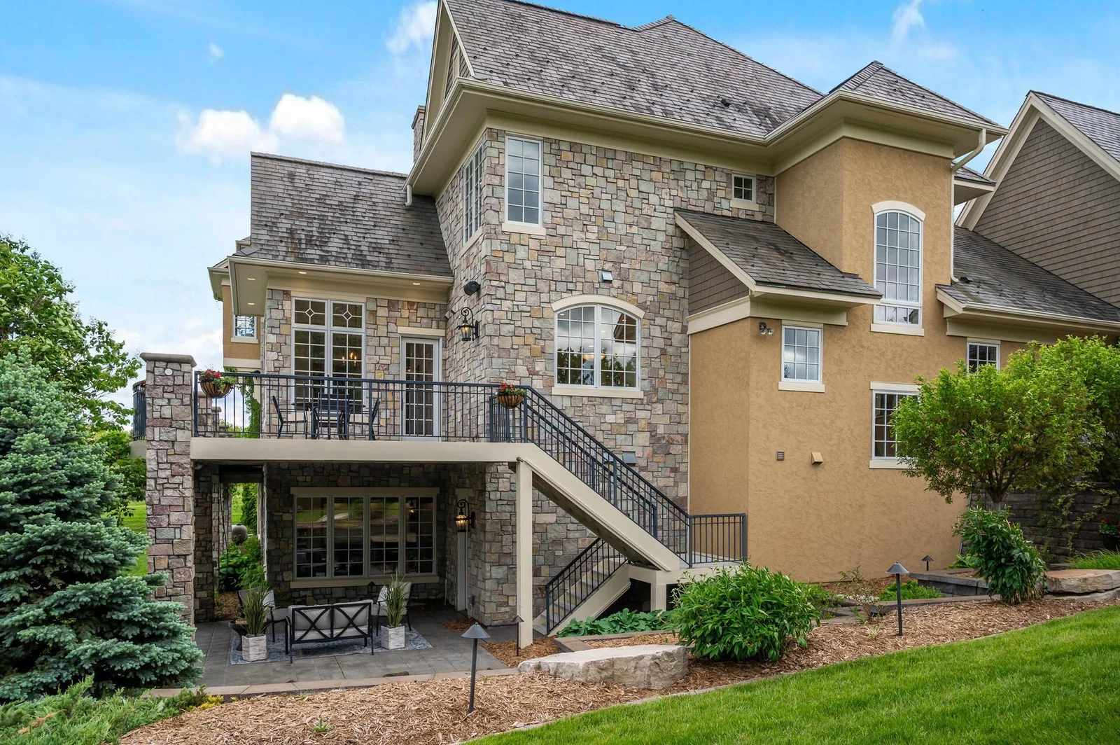 Multi-level outdoor living with a spacious deck and inviting patio.