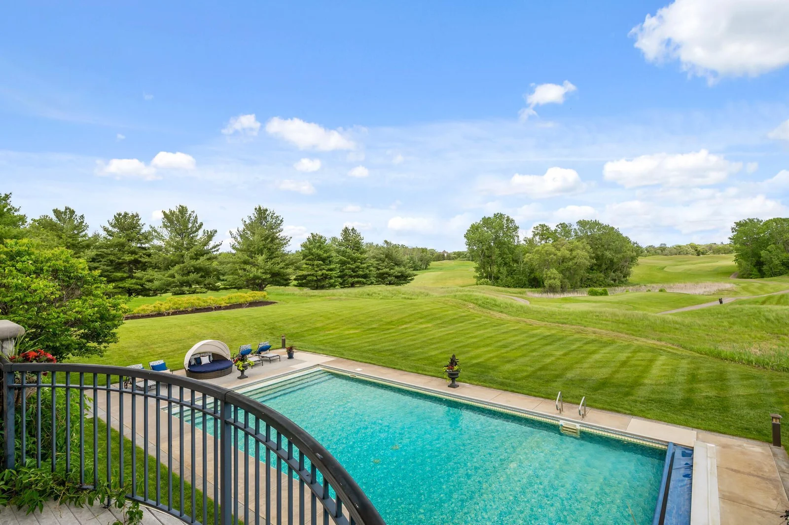 Take in the expansive views of the pool, surrounding greenery, and the rolling fairways of the golf course from the primary suite balcony.