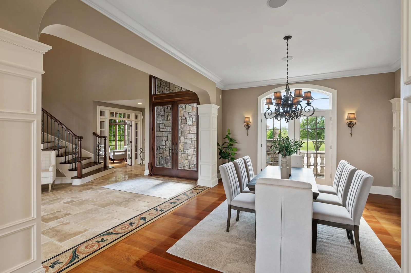 Admire the arched doorways, elegant columns, and natural light that define the foyer and dining room.