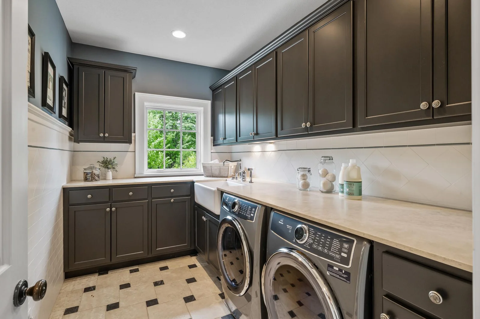 Even the utility spaces are stylish in this conveniently designed and spacious laundry room complete with modern washer and dryer, tile flooring and utility sink.