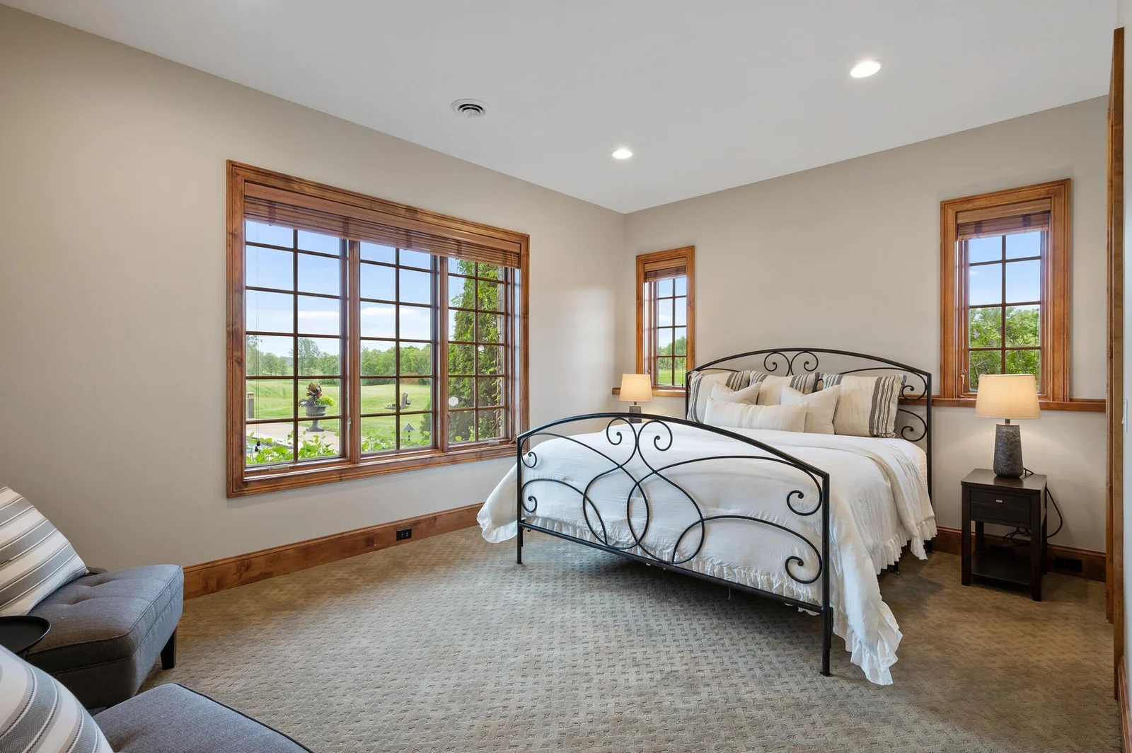 Create a comfortable and bright haven in this lower level bedroom, enhanced by the natural light streaming in from multiple windows.