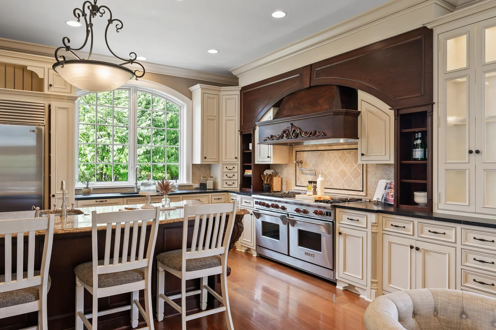Natural light floods this gourmet kitchen through its beautiful arched window overlooking the scenic surroundings.