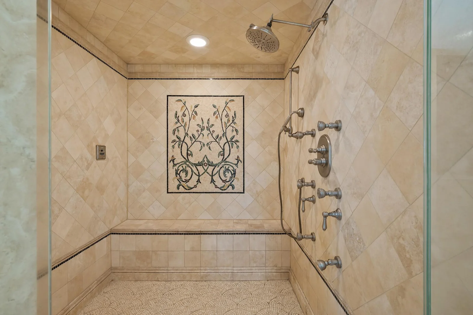 Luxurious walk-in shower with multiple shower heads and a built-in bench.