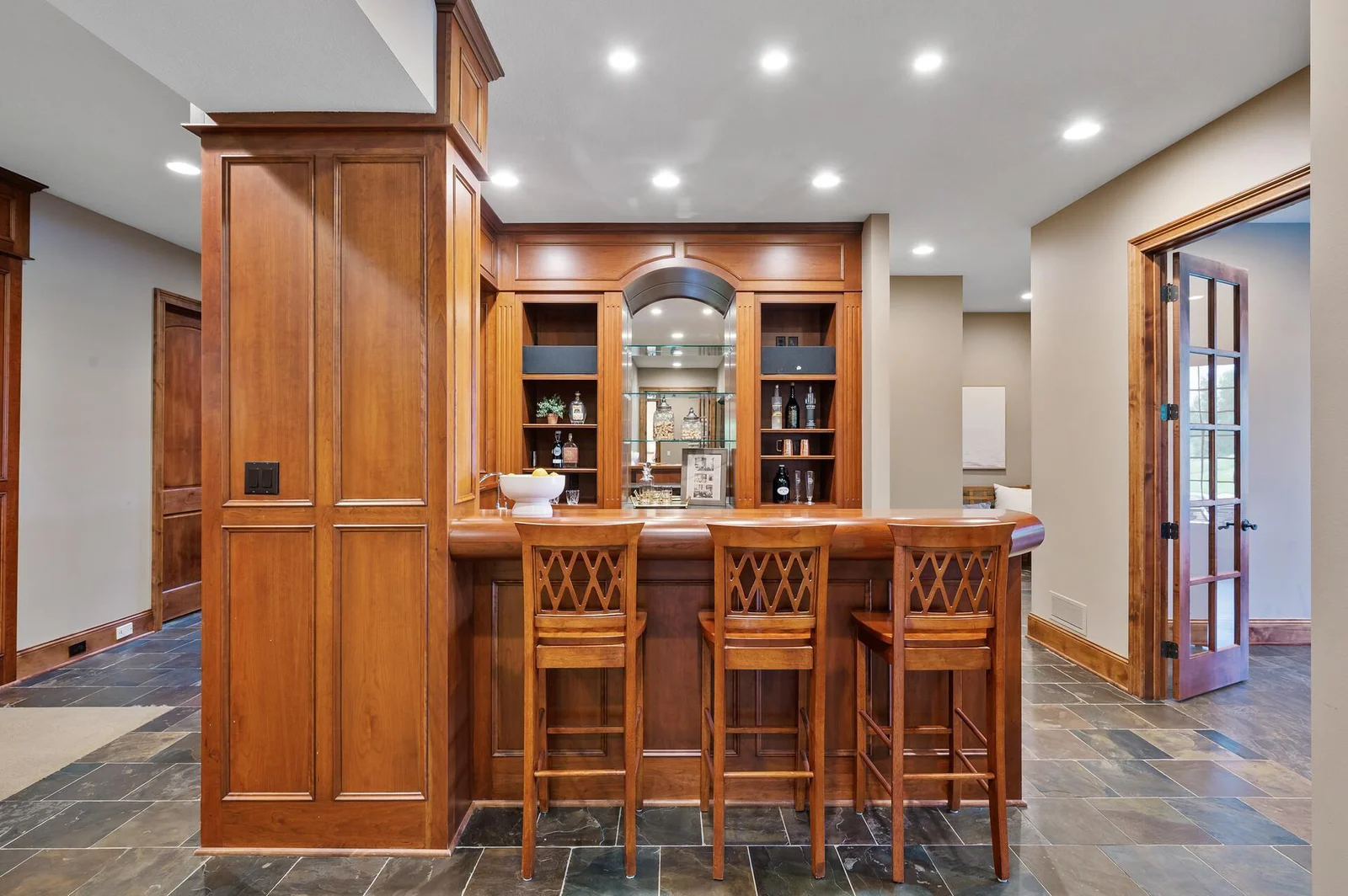 Recessed lighting illuminates this beautiful custom bar, creating a warm and inviting ambiance on the lower level.