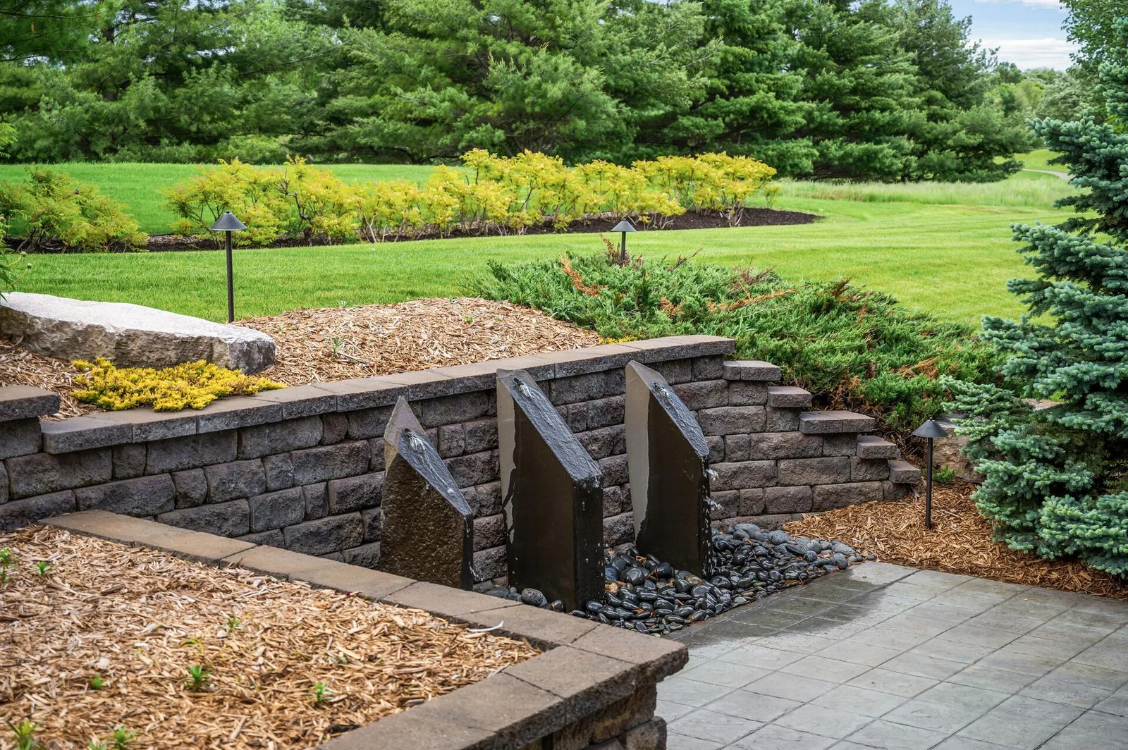 This striking water feature adds a unique design element and a peaceful ambiance to the outdoor space.