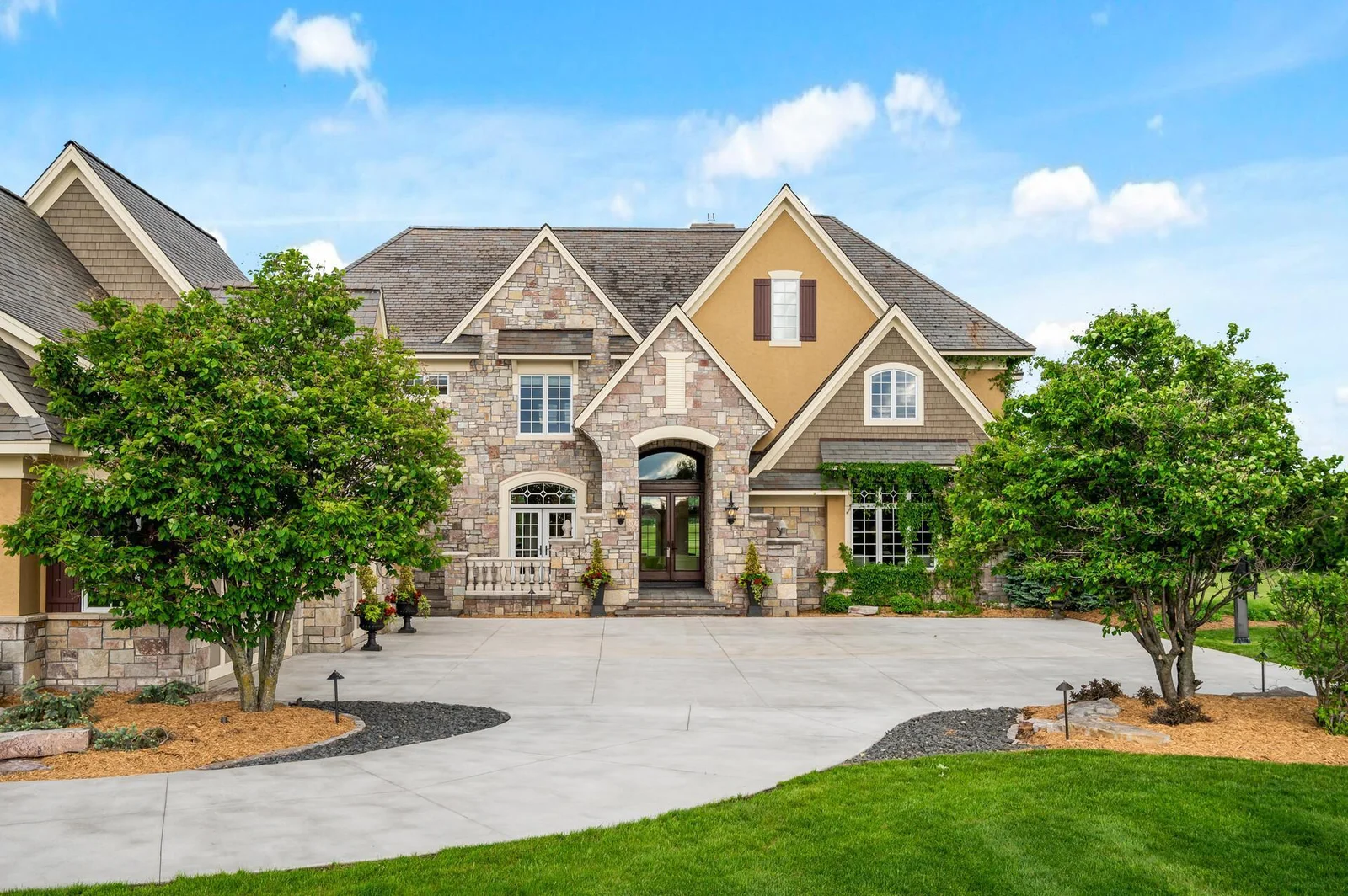 Notice the harmonious blend of natural stone, stucco, and landscaping that enhance the beauty of this home.