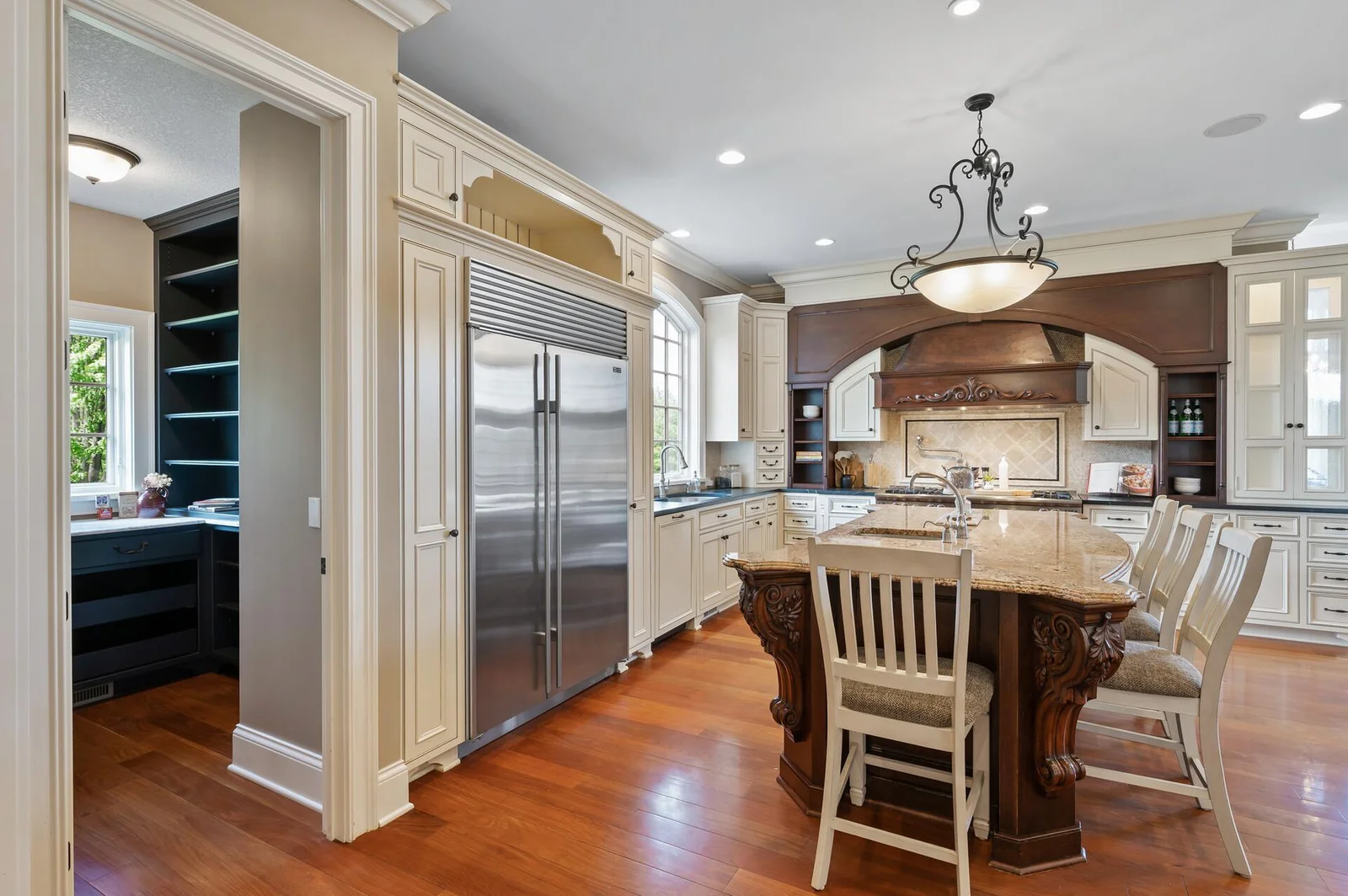 Seamlessly integrated Sub-Zero refrigerator and convenient pantry access are key features of this gourmet kitchen.