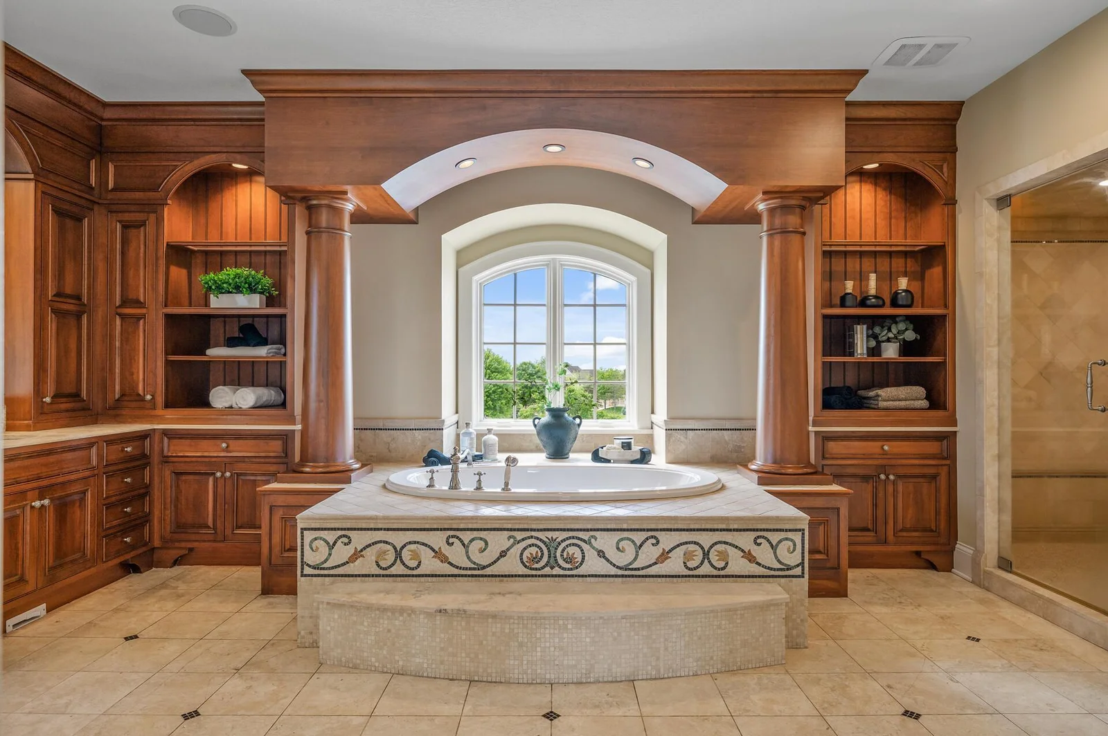 Exquisite custom wood cabinetry and thoughtful design details define this opulent bathroom.