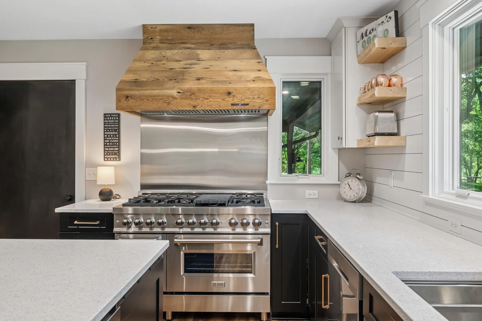 Custom touches throughout elevate the space: live edge slab shelves, custom natural wood range hood, ZLINE 8 burner professional range.