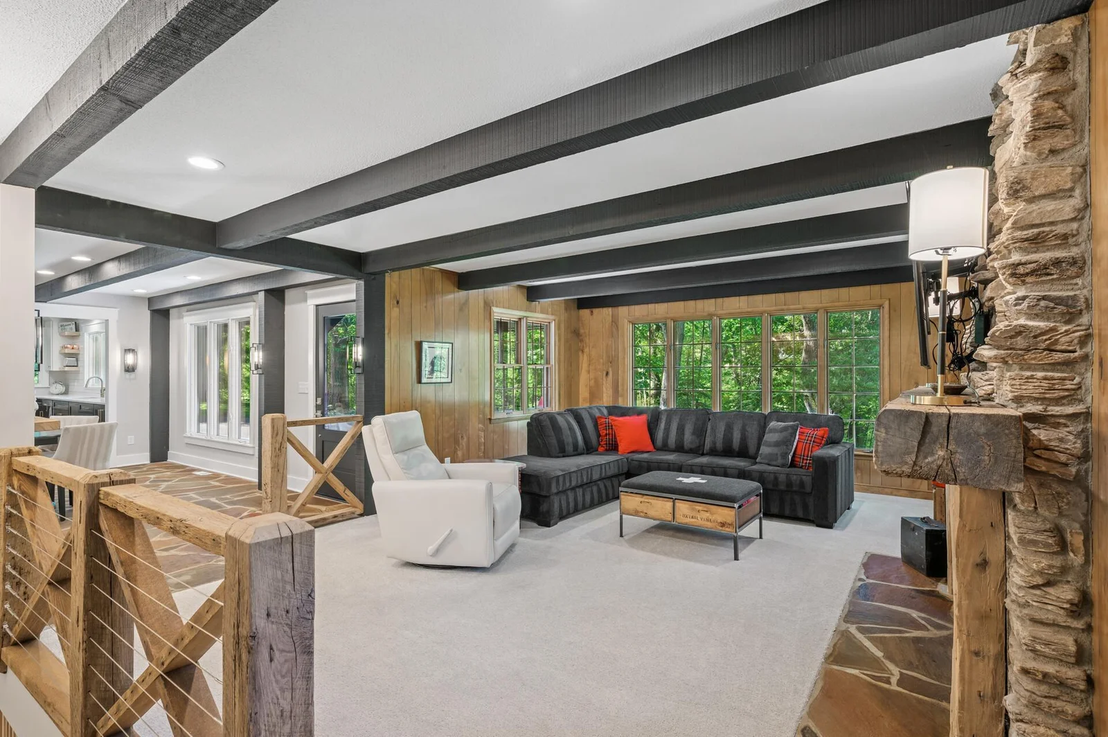 Additional large living room off the dining area has tons of natural light with new Pella windows, flagstone flooring and riverrock surround for wood burning fireplace.