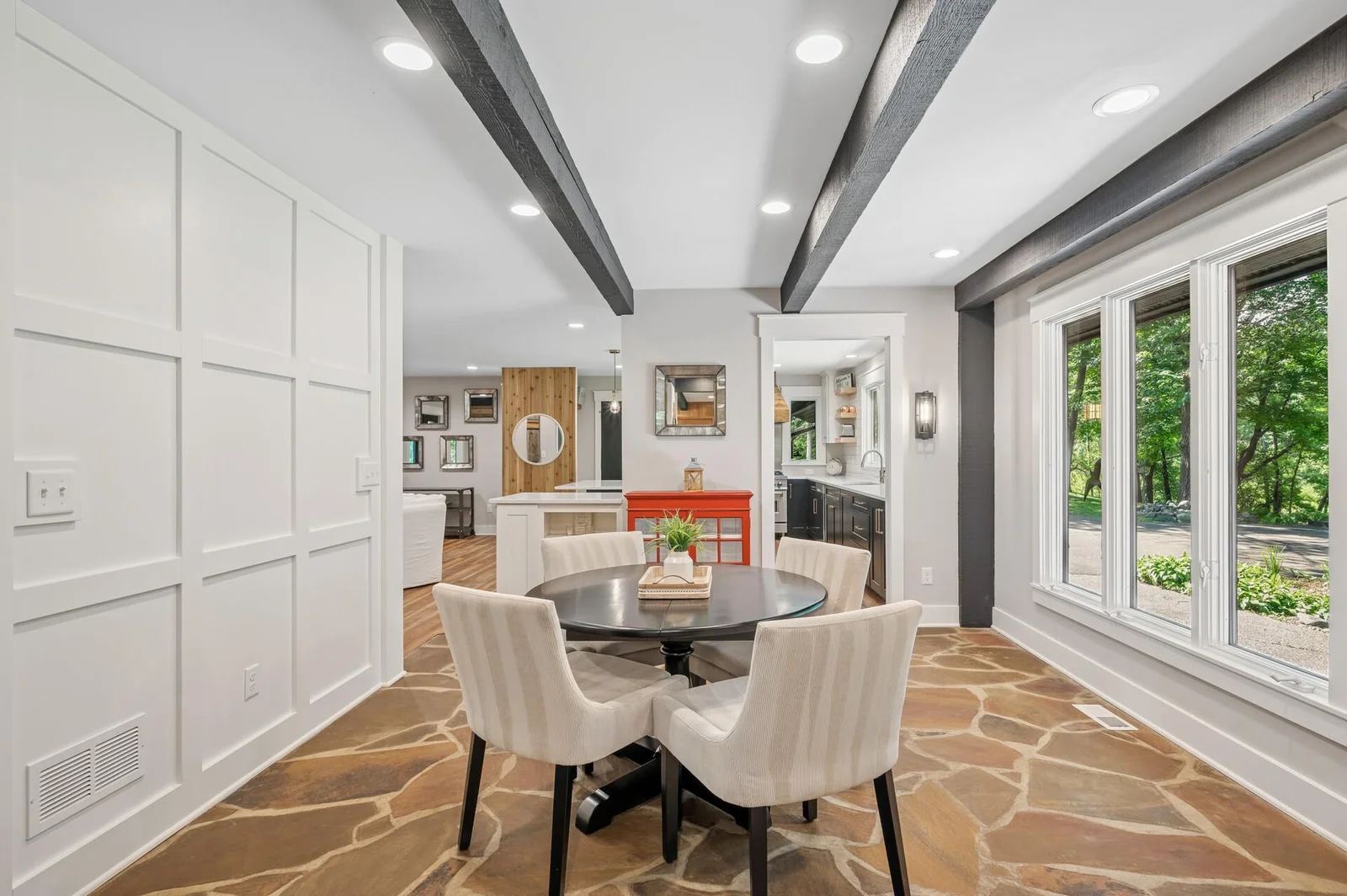 Touches of the homes heritage greet you as you enter the home.  Original flagstone floor where each piece was hand selected by the original builder blend seamlessly with modern new Pella Windows, wood accent wall and open concept main level.