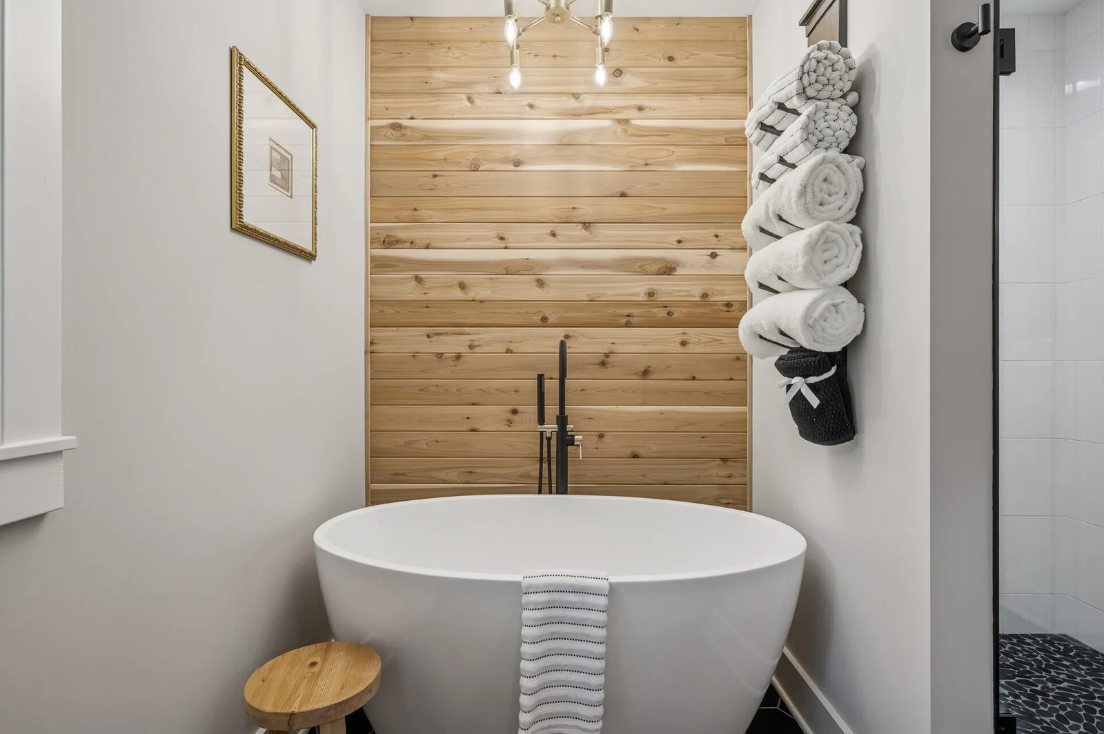 Free standing soaking tub with wood plank accent wall feels like a spa escape in your own home!