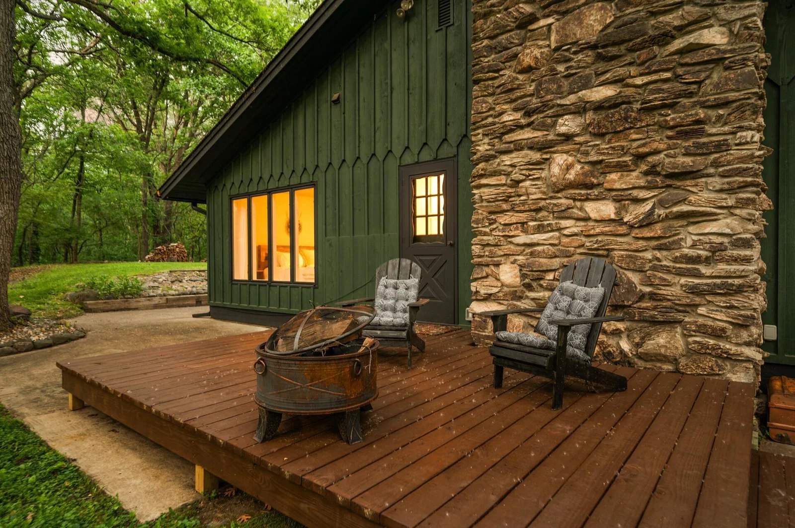 Deck off the living space on side of the home accented with stone fireplace and adjacent patio creates a relaxing space to unwind or entertain.