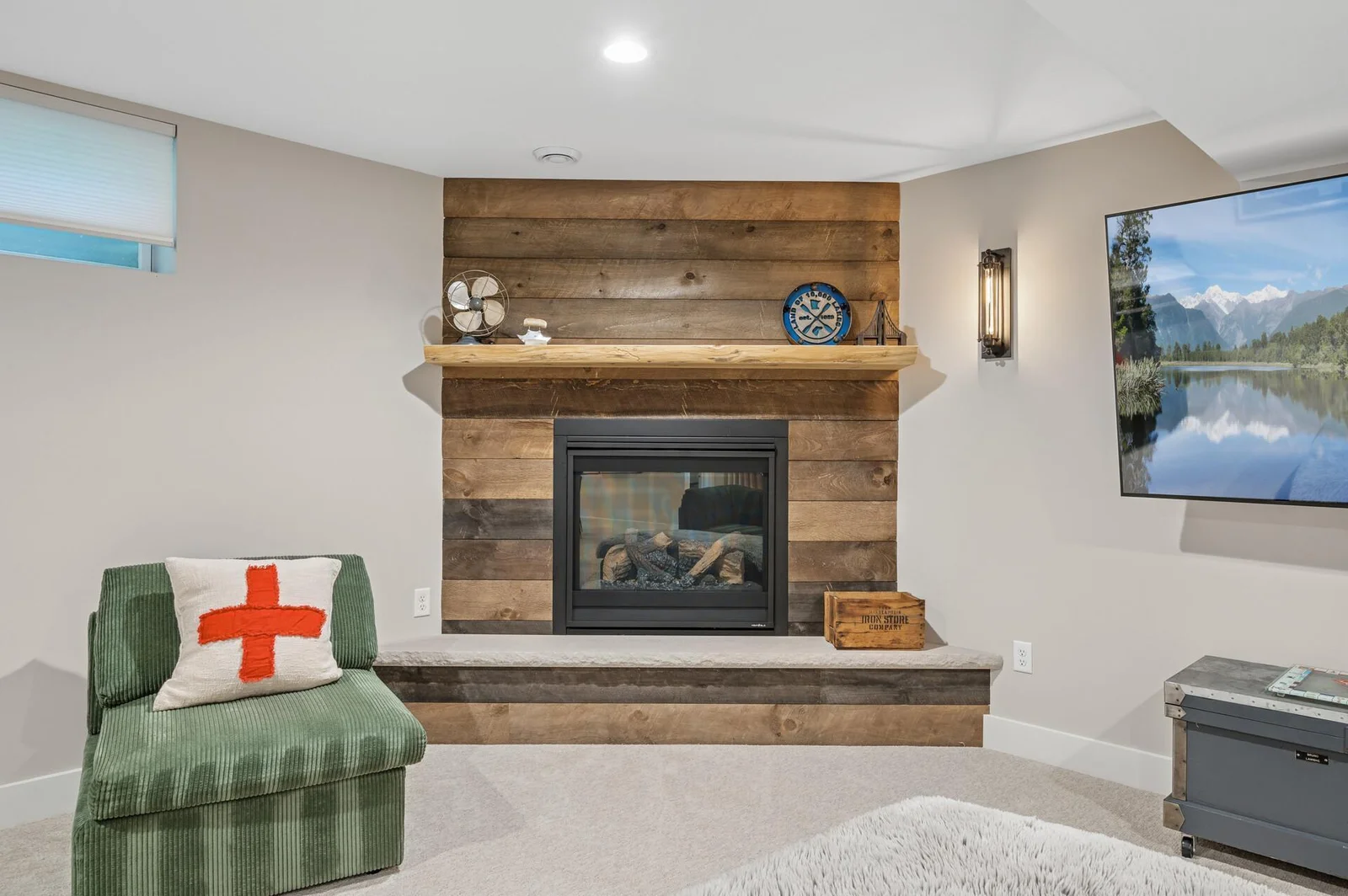 Gas fireplace with wood plank surround makes a warm and cozy space for cold winter nights.