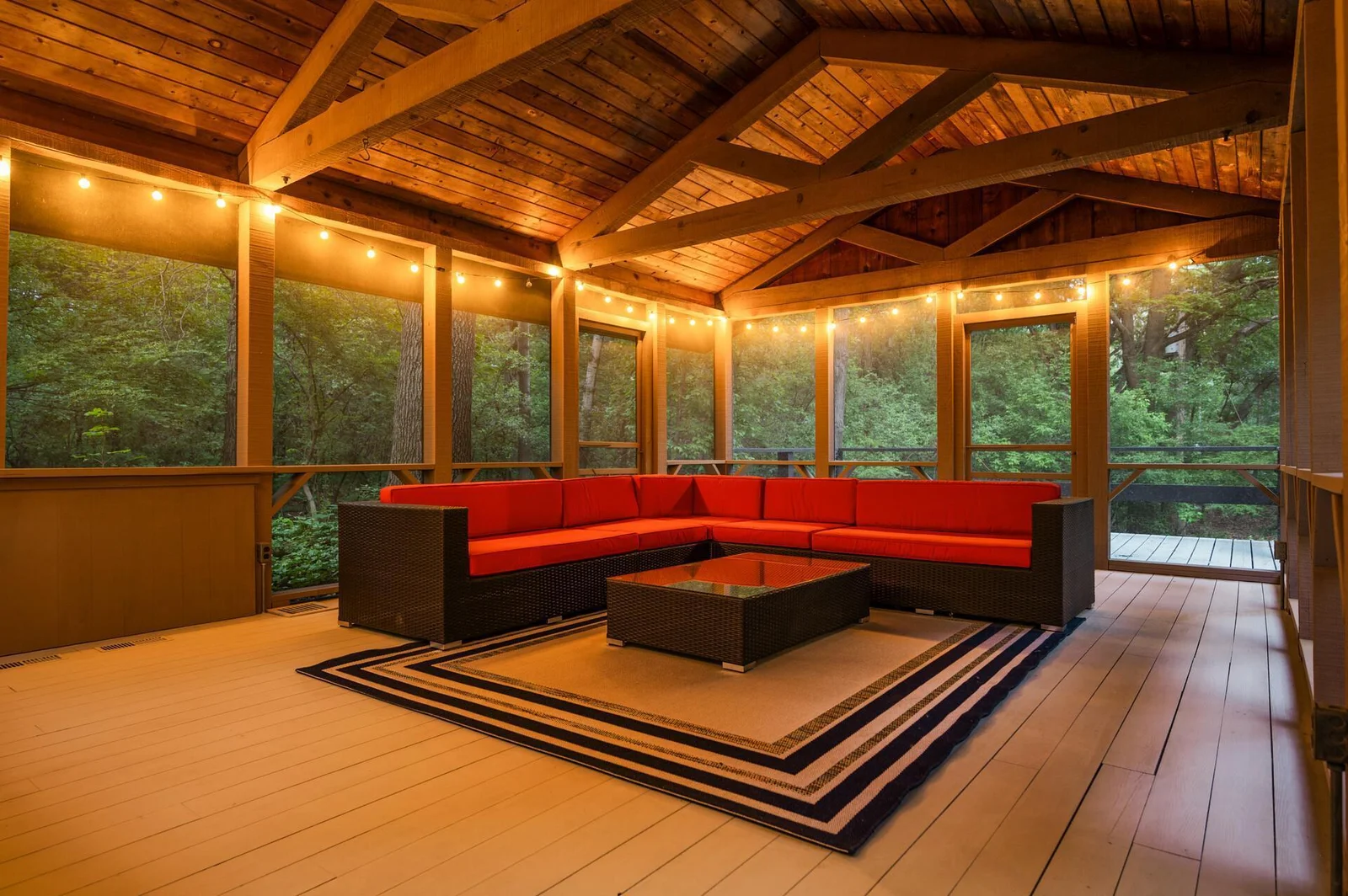 Massive screened in porch with vaulted beam ceiling nestled by the privacy of mature trees lets you enjoy the outside space in this tranquil setting.
