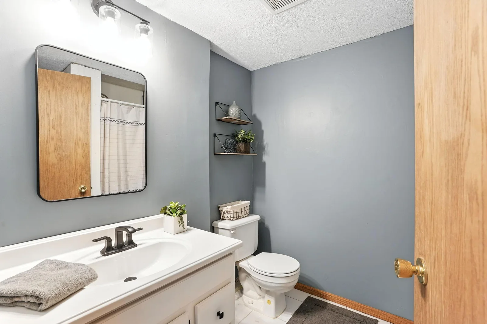 Lower level 3/4 bath with tile flooring & shower, newly updated fixtures