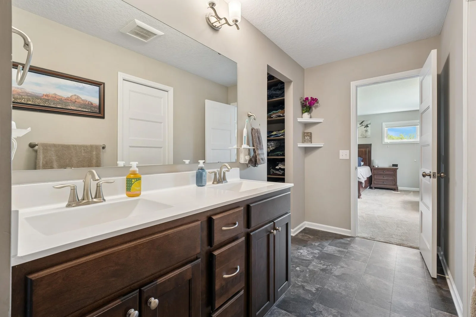Double sinks, private toilet, walk-in closet, and large shower in private, primary bathroom.