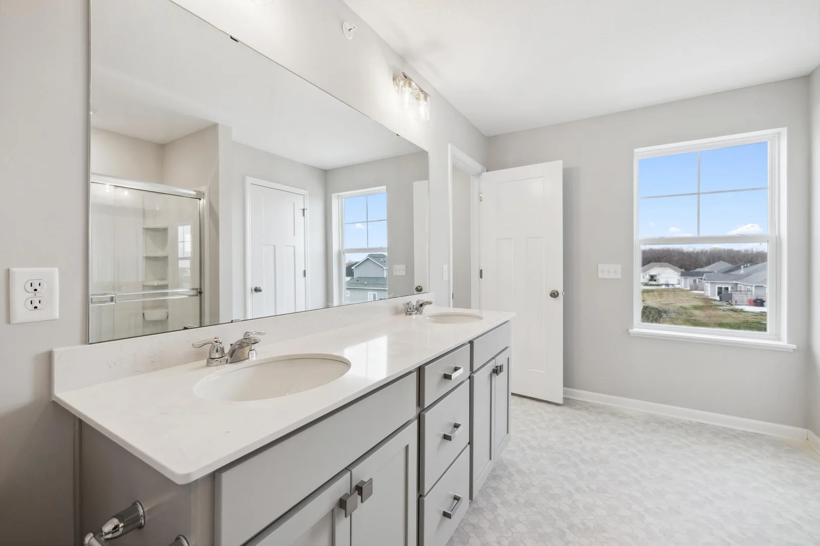 Owner's bathroom with dual sinks, virtually staged.