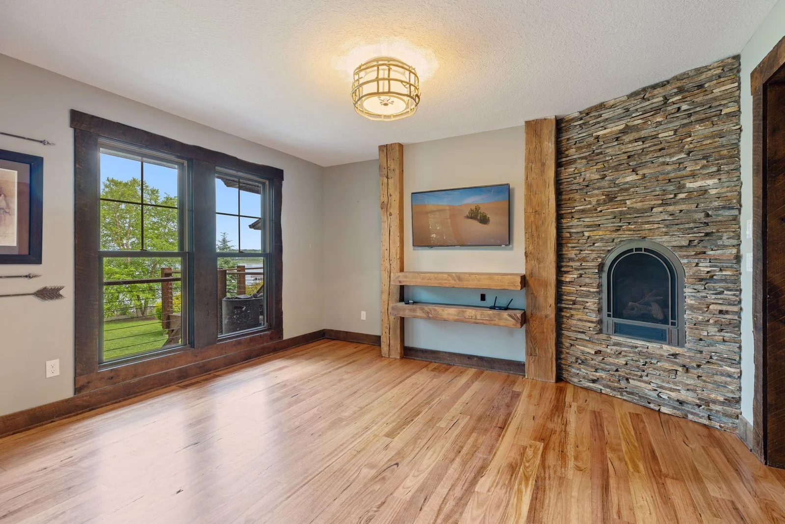 The sitting room off the main-floor primary bedroom features a gas fireplace and lake views