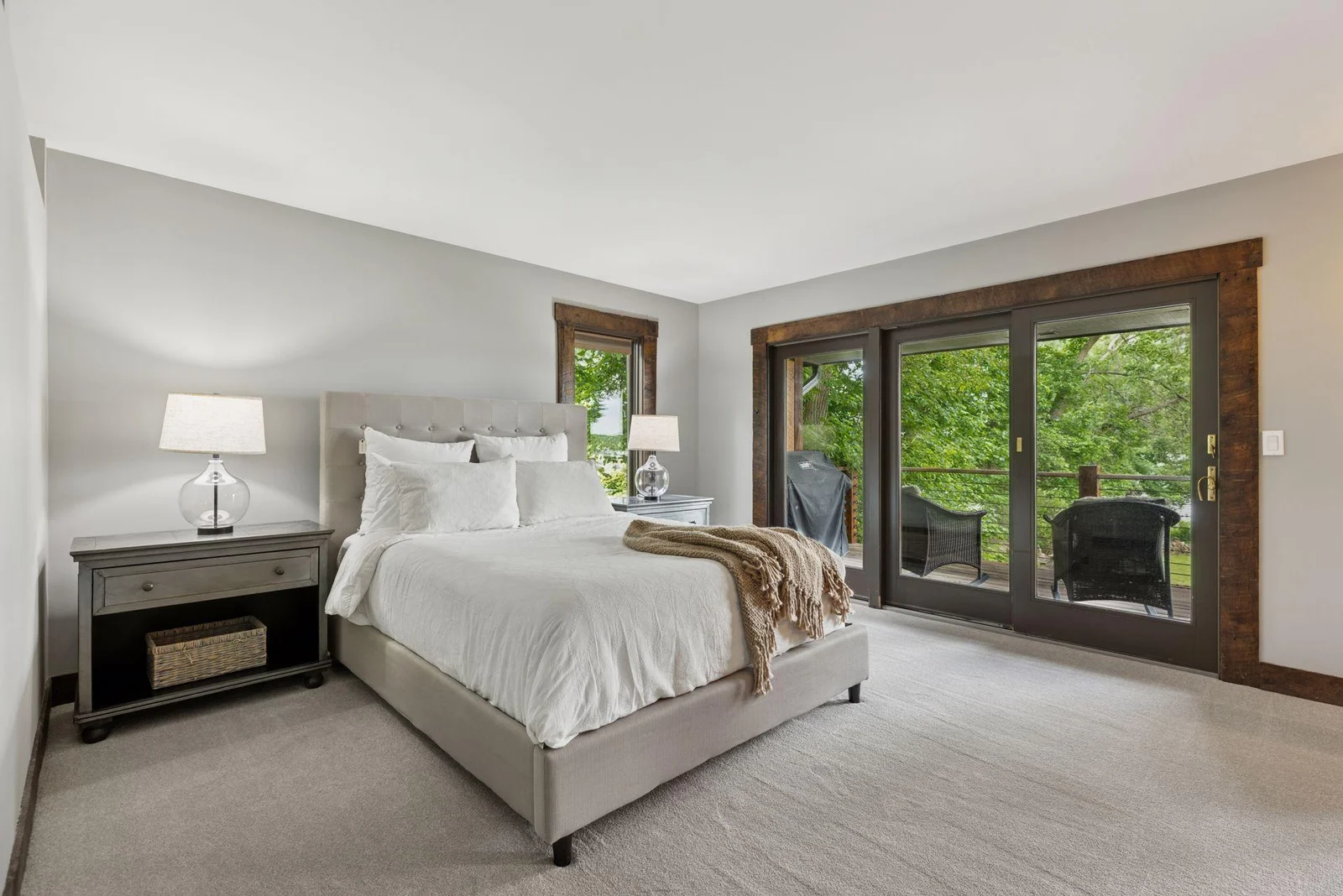 Main level primary bedroom with private deck, the perfect place to watch the sunrise.