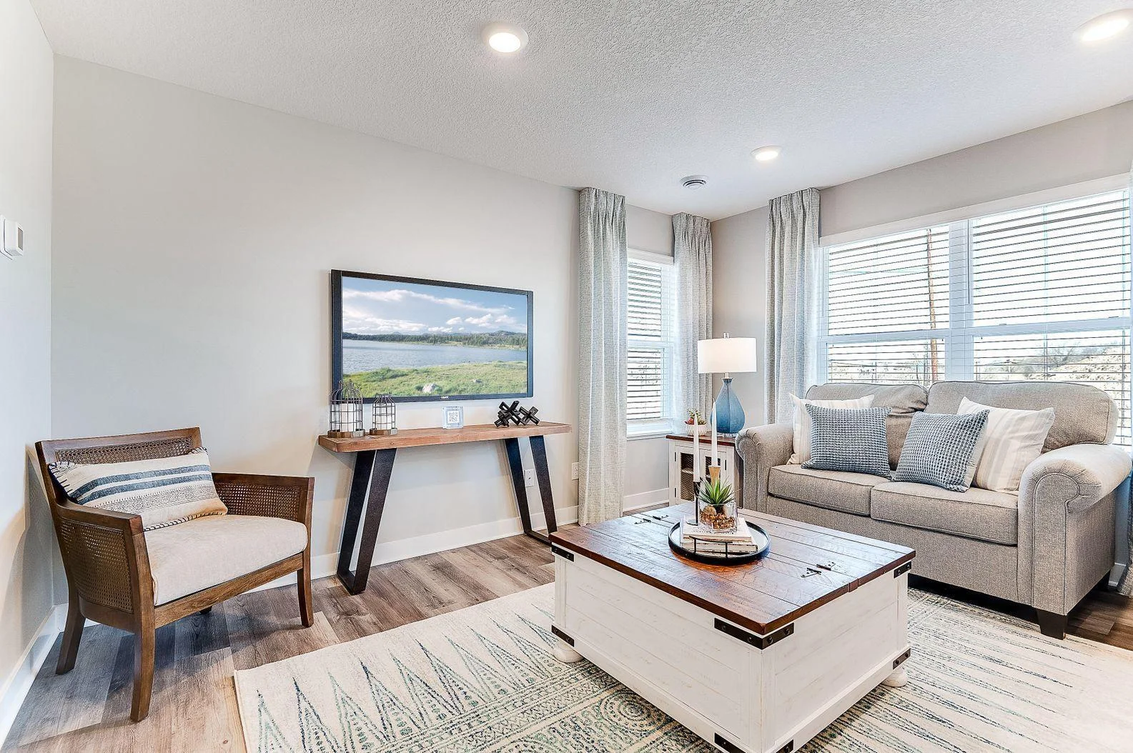The main living space is open and full of light with an abundance of windows. (Model photo, colors may vary)