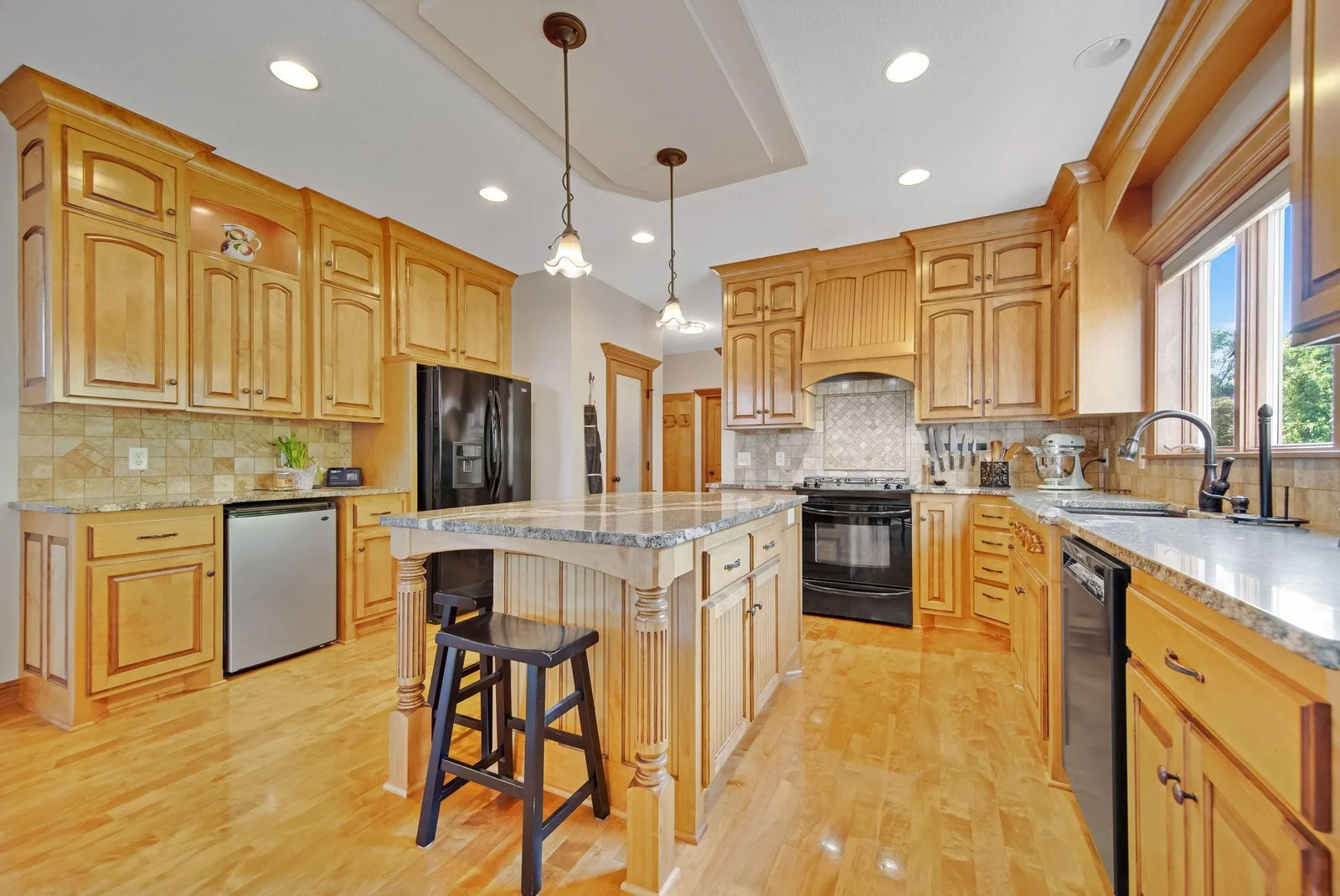 Chef's kitchen with upgraded cabinets, granite countertops, pantry, and tile backsplash!