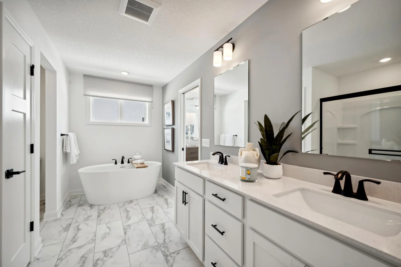 (Photo of a decorated model, actual homes finishes will vary) An extension of the primary bedroom, this private and spacious bath contains a double-vanity, a soaking tub, a shower and a walk-in closet.
