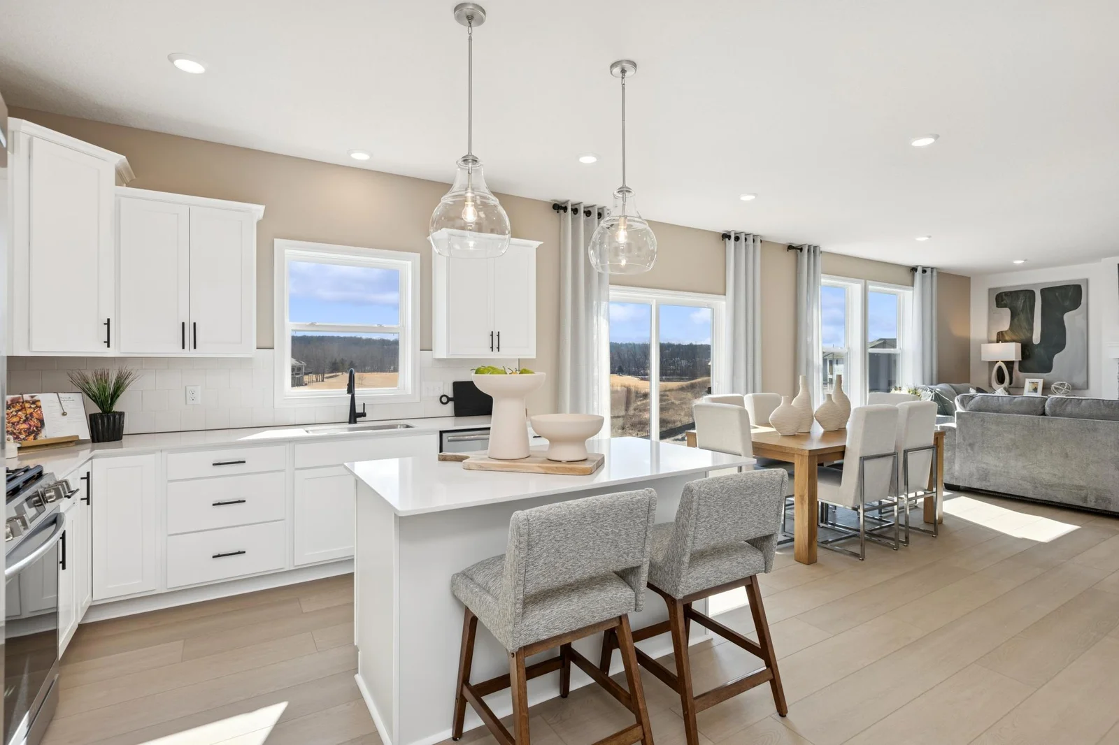(Photo of a decorated model home, features and finishings will vary) A sit-in kitchen and nearby dining room.