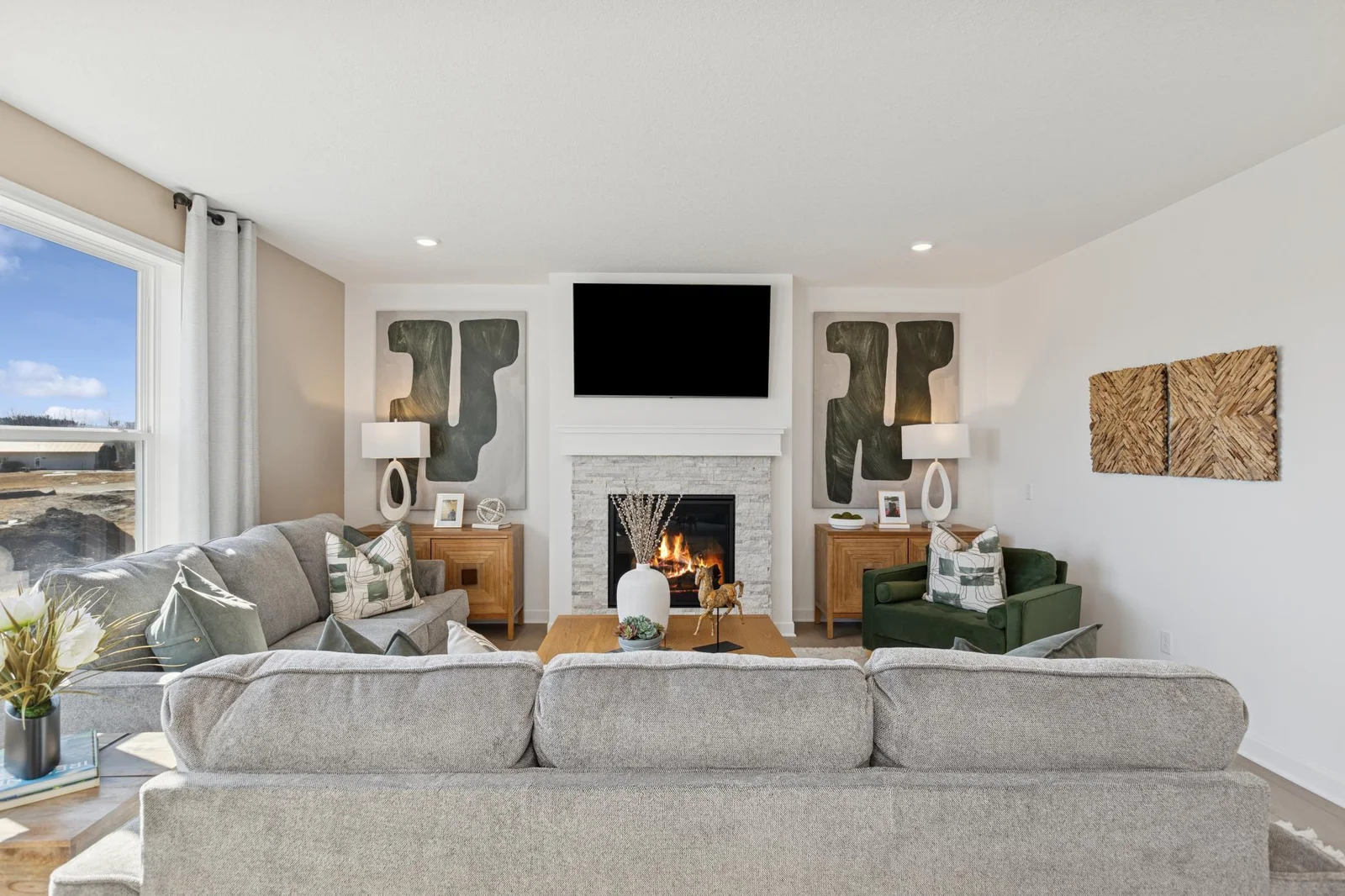 (Photo of a decorated model home, features and finishings will vary) The electric fireplace at this home anchors the living space.