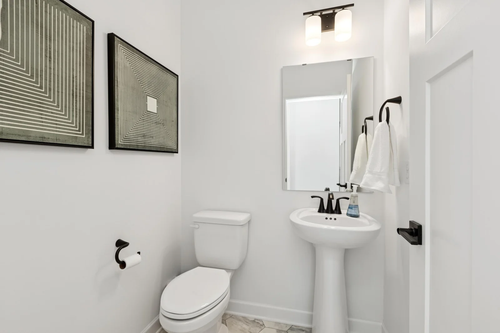 (Photo of a decorated model home, features and finishings will vary) The main level half bath.