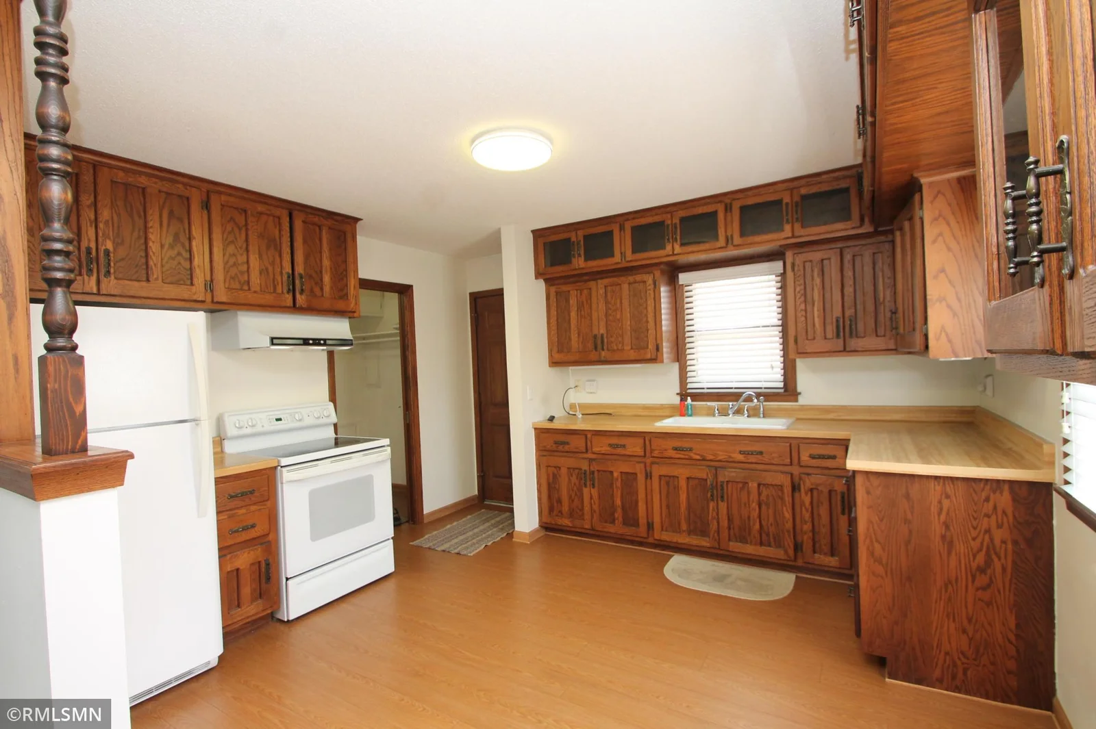 The kitchen features custom oak cabinetry and the fan hood vents to the outside!  Newer flooring.