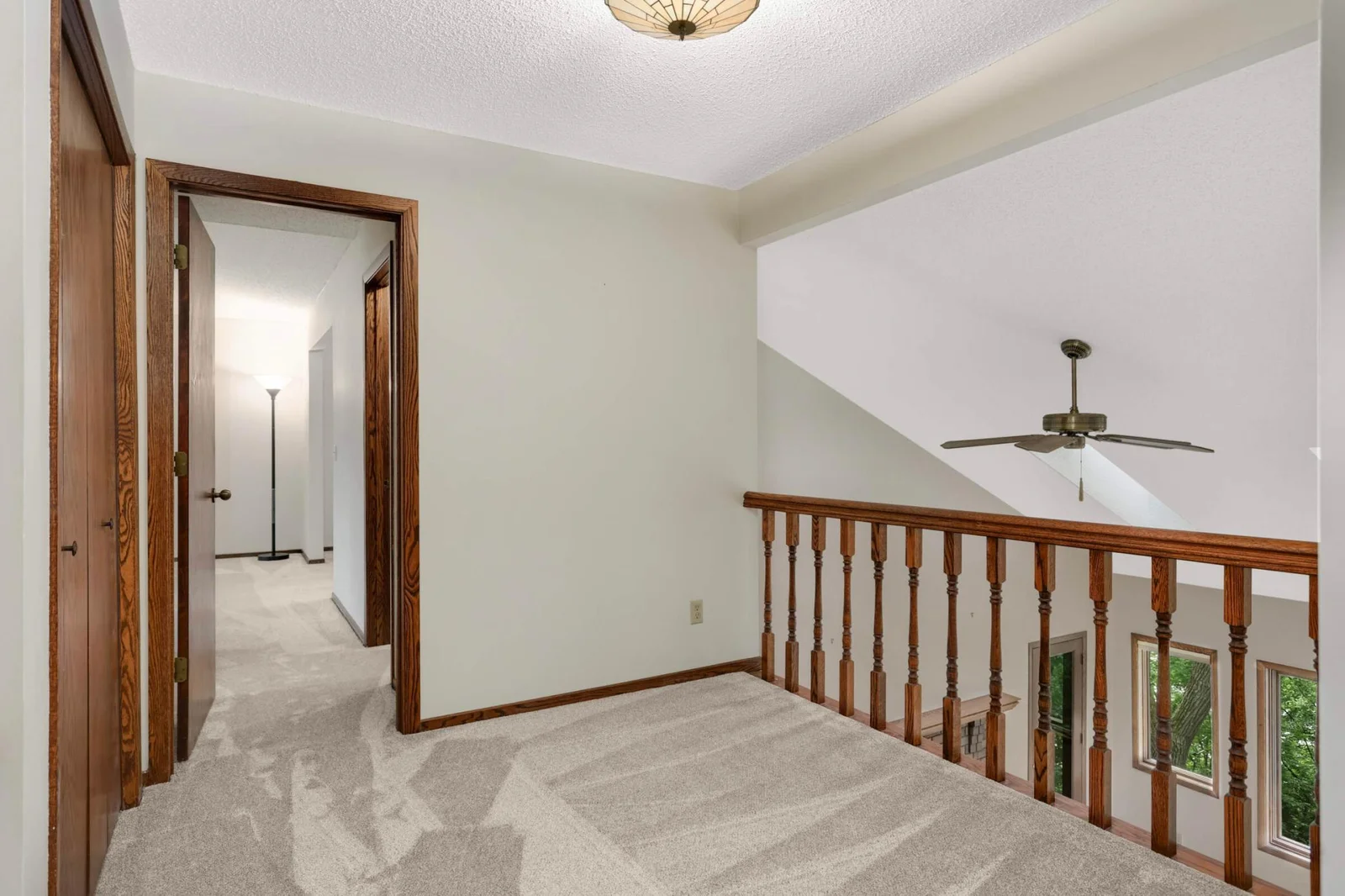 Upper level hall overlooking living room leading to 2 additiona bedrooms and full bath