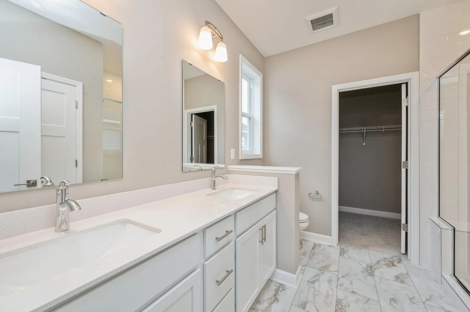 (Photo of similar home, features will vary) The en-suite bathroom features a walk-in shower with glass enclosure and convenient shelving to store bathing essentials