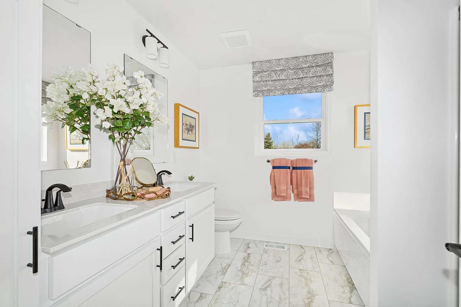 (Photo of a decorated model, actual homes finishes will vary) The primary bath features a double-vanity, a shower, and a separate soaking tub.