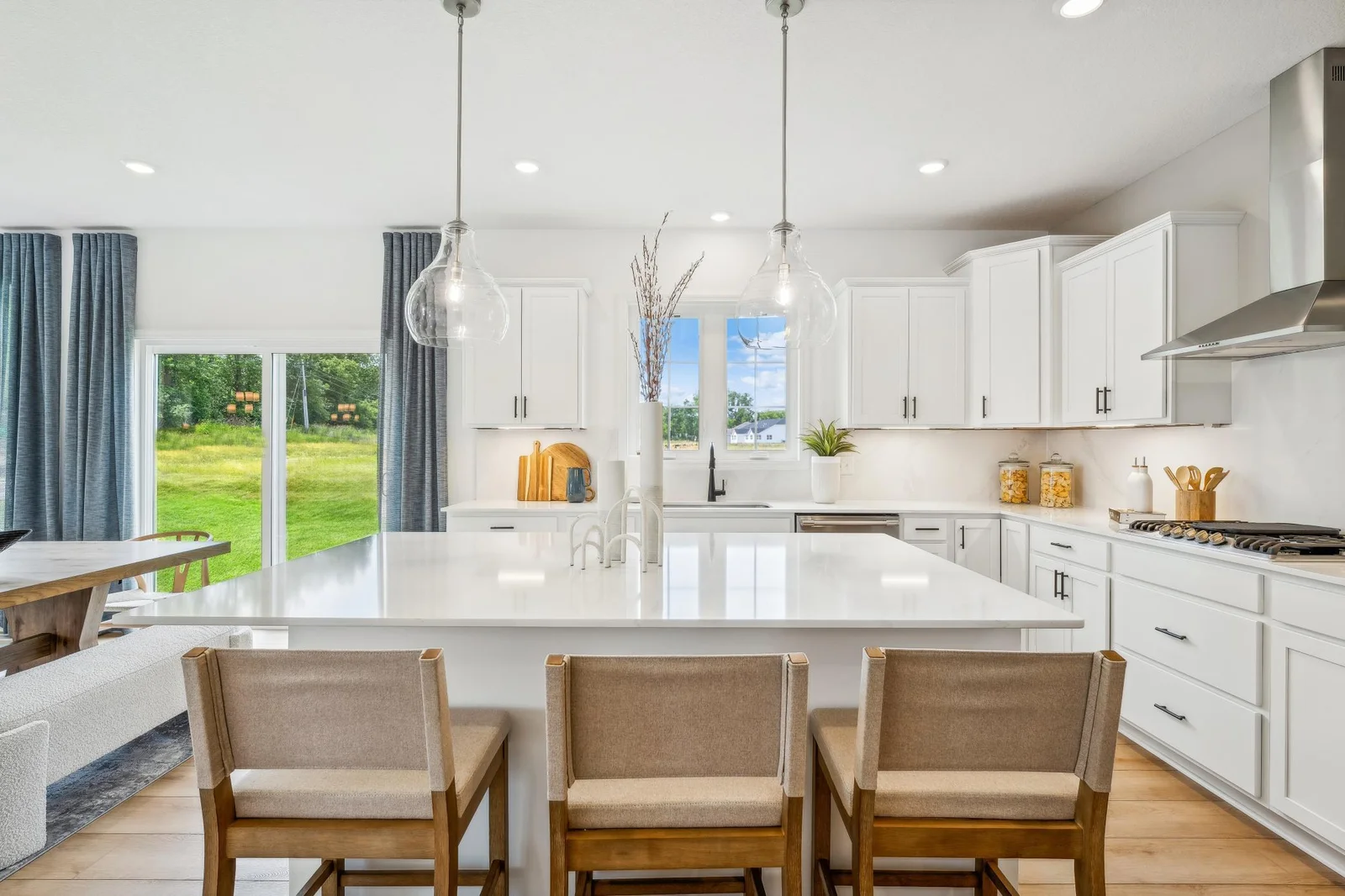 (Photo of a decorated model, actual homes finishes will vary) The stunning gourmet kitchen features a large center island, quartz countertops, LVP floors, stainless appliances and more!