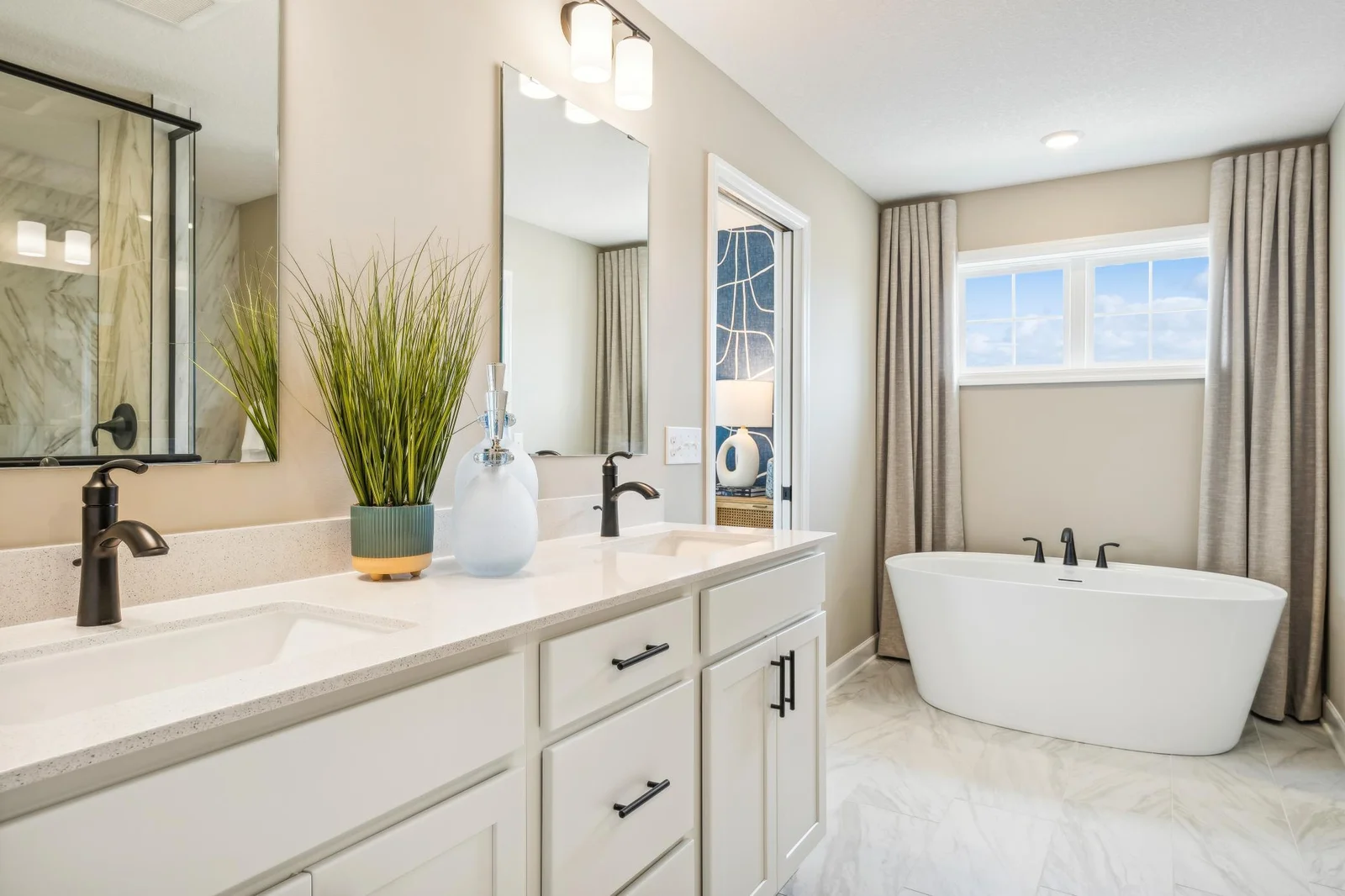 (Photo of a decorated model, actual homes finishes will vary) An extension of the primary bedroom, this private and spacious bath contains a double-vanity, a soaking tub, a separate serenity shower and a walk-in closet.