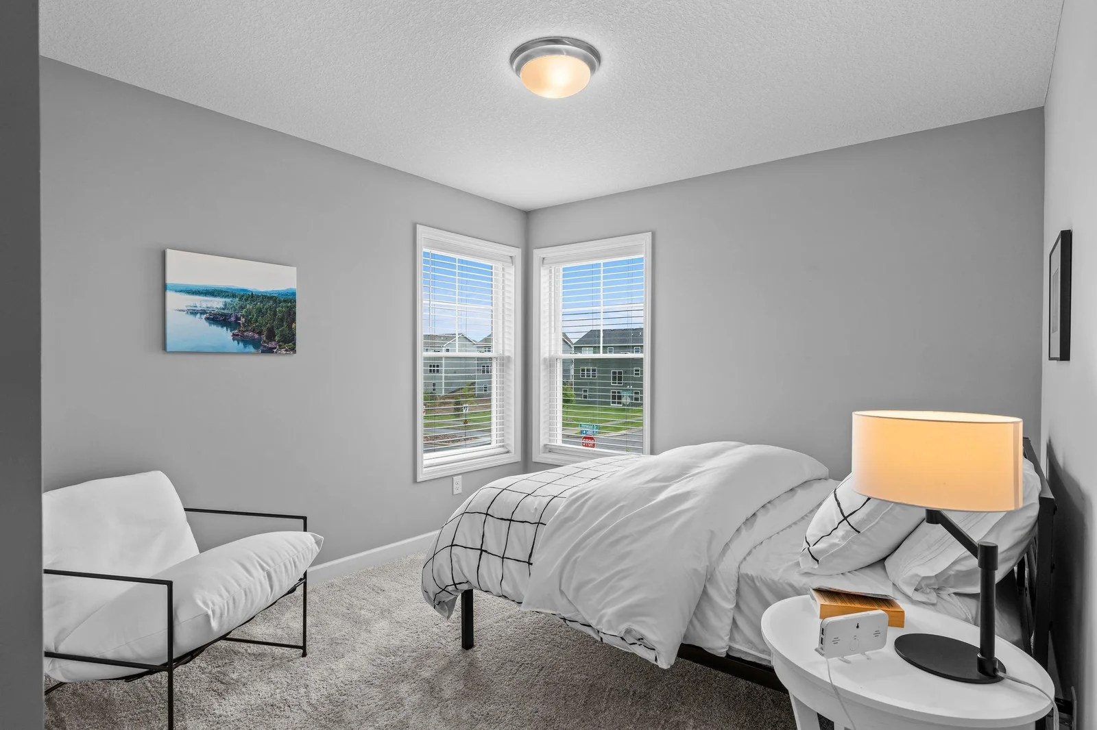 View of Bedroom Two featuring carpeted flooring and rear- and side-facing windows.