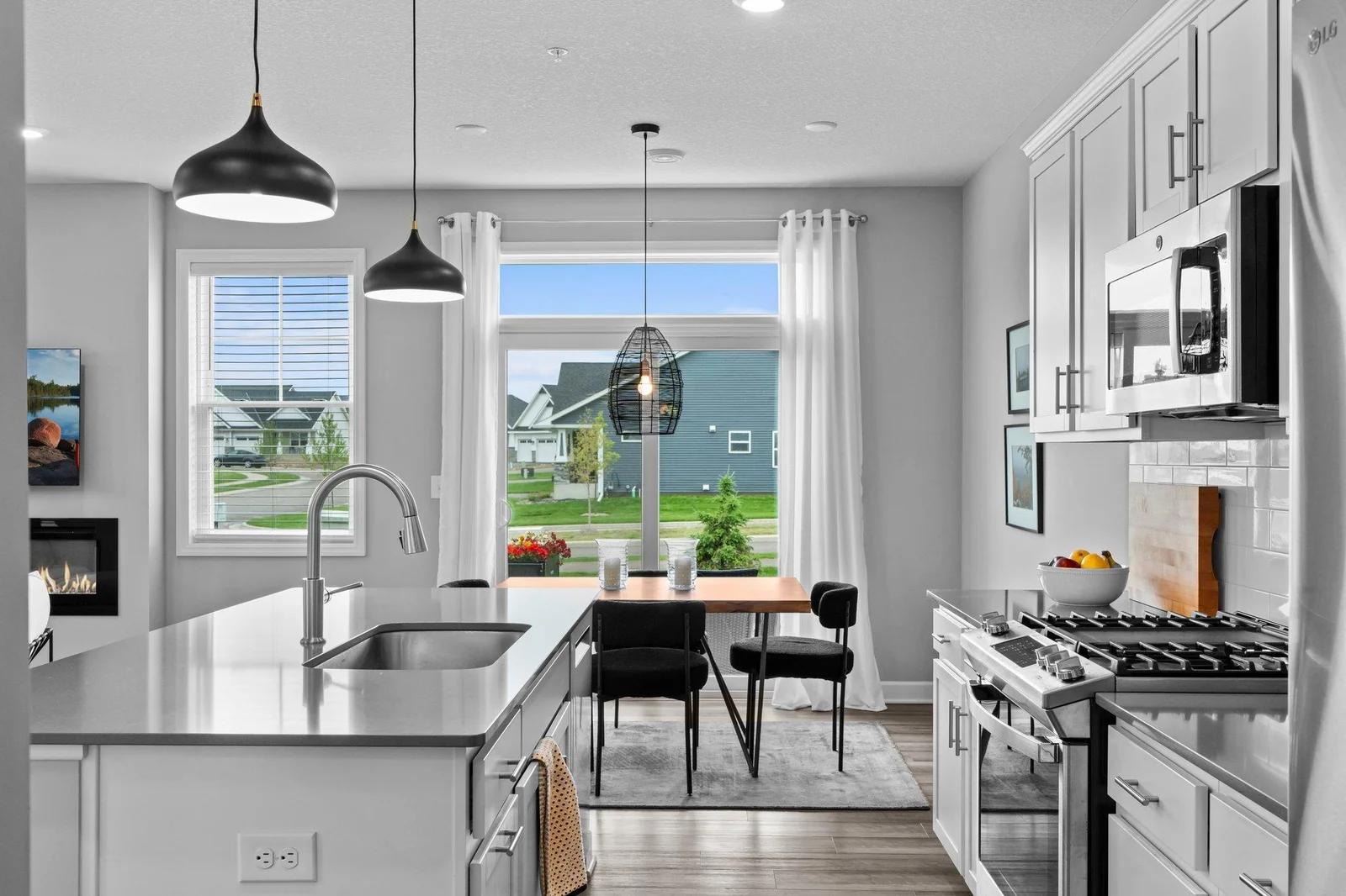 A spacious center island with breakfast bar seating, accented by modern pendant lighting, provides the perfect space for casual dining or entertaining. A generous 4x4 walk-in pantry adds even more functionality and storage.