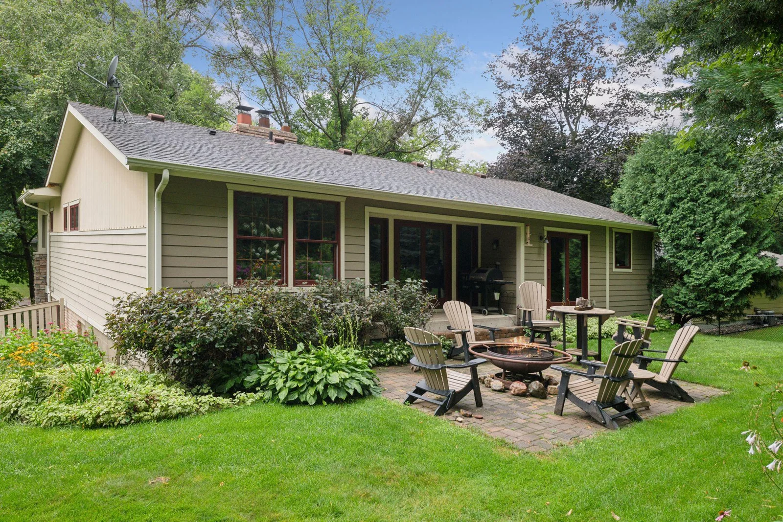 Perennials galore surround the paver patio, a perfect spot for a firepit.