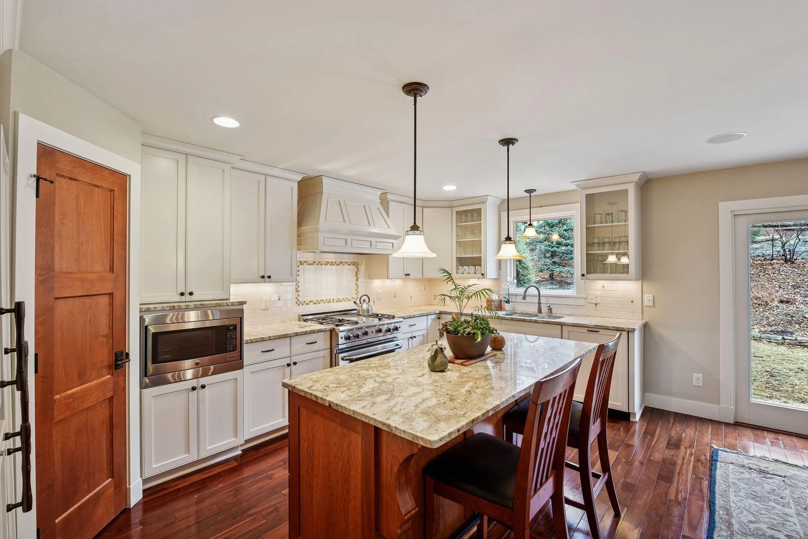 The combination of the white enameled cabinetry and deep hues of the cherry woodwork make the kitchen pop.